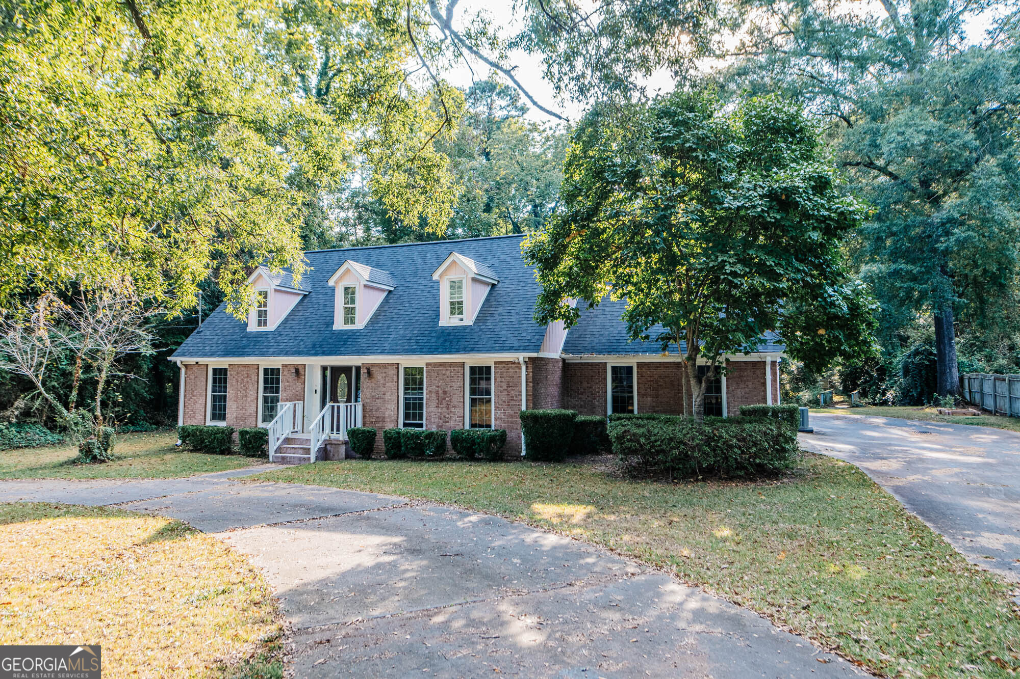 Discover this charming 4 BR, 3.5 BA home nestled in the sought-after Wesleyan Woods neighborhood. Featuring an open floor plan, the kitchen, dining room, and living area, all with hardwood flooring, flow seamlessly, creating an inviting space for entertaining. A family room with bookshelves and a decorative double-sided fireplace adds warmth and character, while the versatile loft area above with pull-down stairs is ideal for a home office, cozy reading nook or creative space. The primary suite on the main level offers hardwood floors, an ensuite with double vanity, whirlpool tub, separate shower, walk-in closet, and even a convenient laundry closet with washer/dryer hookup. Upstairs, three spacious bedrooms and two full baths provide comfort for family or guests. Enjoy your morning coffee or evening relaxation in the sunroom overlooking a private, large backyard-ideal for kids, pets, or gatherings. A circular driveway adds convenience and curb appeal. This home is priced to sell and being offered as-is. With a little TLC, you can transform this beauty into your forever dream home. Located near schools, shopping, and restaurants, it's an opportunity you don't want to miss.