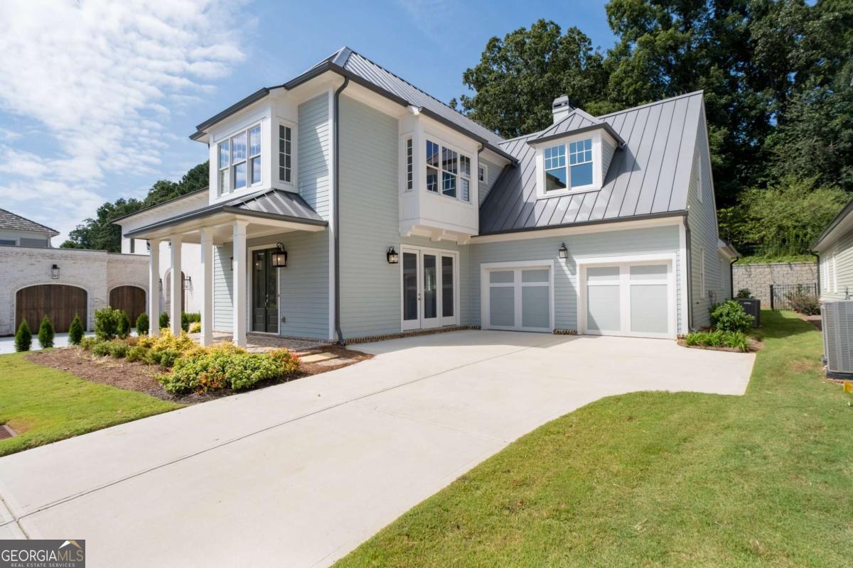 Ask about our preferred lender incentives and a 5% rate! Discover a home that perfectly balances elegance, comfort, and versatility in the heart of Vickery. This 5-bedroom residence offers a thoughtfully designed layout with flexible spaces to fit your lifestyle. One main-level bedroom doubles as a private home office, while the upstairs flex room easily transforms into a junior suite, media lounge, or guest retreat. The primary suite is conveniently located on the main level, creating a private haven just steps from the heart of the home. A formal dining room sets the stage for memorable gatherings with its brick accent walls and cozy fireplace. The chef's kitchen is a true showpiece, featuring a 36-inch Wolf gas range, sleek vent hood, quartz countertops, ceiling-height soft-close cabinetry, and a walk-in pantry with custom wood shelving. The inviting great room boasts tongue-and-groove planked walls and a fireplace, seamlessly opening to a covered brick porch with soaring ceilings. Extend your living outdoors on the brick patio, complete with a stone wood-burning fireplace-ideal for al fresco dining or relaxed evenings under the stars. Upstairs, the junior suite includes a built-in workspace for remote work or study, while three additional bedrooms-two with en-suite baths-offer comfort and privacy for family and guests. Just minutes from the shops and restaurants of Vickery Village, this golf cart-friendly community also offers access to the Forsyth County YMCA. Here, you'll find not just a home, but a lifestyle defined by convenience, connection, and charm.