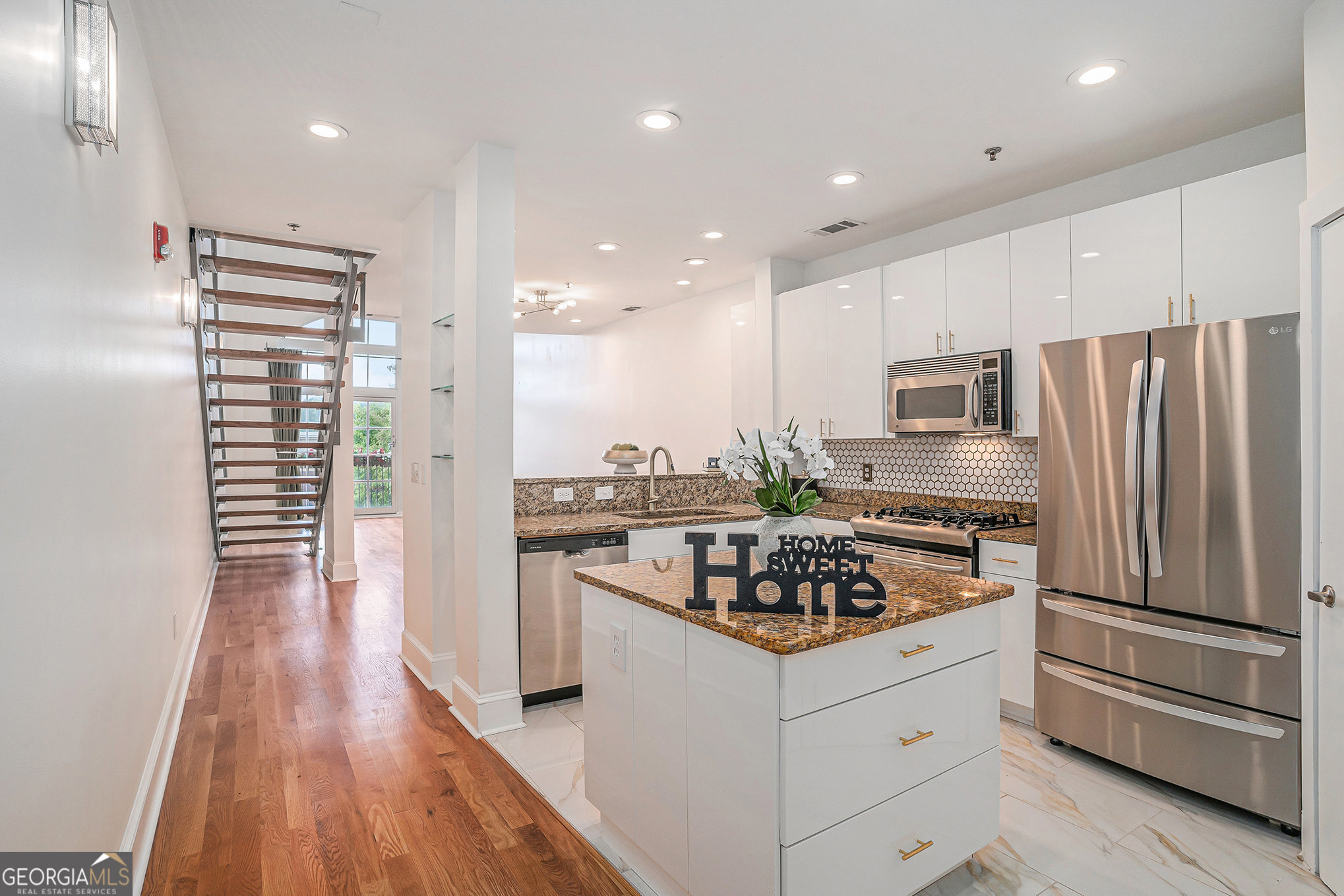 Priced for Quick Sale with Buyer Incentives!! Modern luxury meets everyday convenience in this spacious 2 bedroom, 2.5 bathroom loft located in one of Atlanta's most walkable and vibrant communities. Beautiful updated hardwood floors and sleek white cabinets with gold accents set the tone for a fresh, modern interior. The kitchen offers generous storage, a large island, and a pantry, all flowing into an open living and dining area with soaring ceilings and two-story windows that flood the space with natural light. A convenient half bath is also located on the main level, with a newer HVAC and water heater adding peace of mind. Upstairs, the oversized primary suite includes a walk-in closet and private bath. The second bedroom overlooks the main level and features its own ensuite bath, making it ideal for guests or a home office. Tucked above the Edgewood Retail District, this condo offers unmatched access to everyday essentials. Target, Lowe's, TJ Maxx, Ross, Kroger, and Best Buy are all just downstairs, along with a variety of popular restaurants and neighborhood favorites. You're also just minutes from the BeltLine, Little 5 Points, Inman Park, and MARTA. Seller is motivated and offering Buyer incentives. Call for full details!