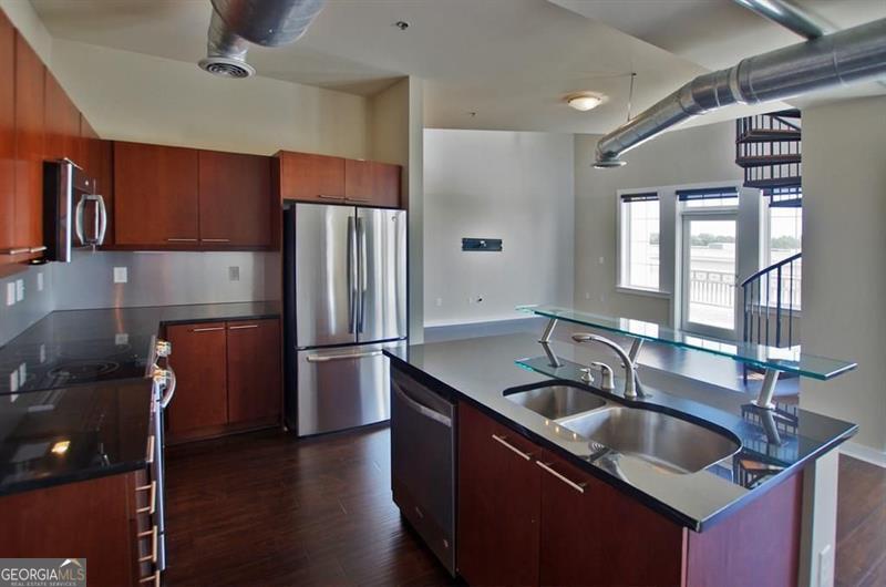 Available September 15 - this fabulous multi-level 2 bedroom, 2 bathroom loft is located in the heart of Atlantic Station and offers the perfect blend of modern style and urban convenience. The open-concept layout features exposed ductwork, rich wood floors, granite countertops, stainless steel appliances, and an in-unit washer/dryer. The second bedroom functions as a loft overlooking the main living space, ideal for a home office or guest area. Enjoy two large, private walk-out balconies with views of the courtyard's water column, public seating, and a dramatic LED-lit city backdrop. The secured-access building includes two reserved, gated, covered parking spaces, and you're just steps from Publix, LA Fitness, Target, Dillard's, Yard House, and countless dining and shopping options. Walking distance to MARTA makes commuting a breeze. Pre-qualification is required for showings (photo ID and verifiable income of at least 3x the monthly rent). Rental requirements include one month of pay stubs or a bank statement, a satisfactory credit score, rental history, and a background check. Final approval at the owner's discretion.