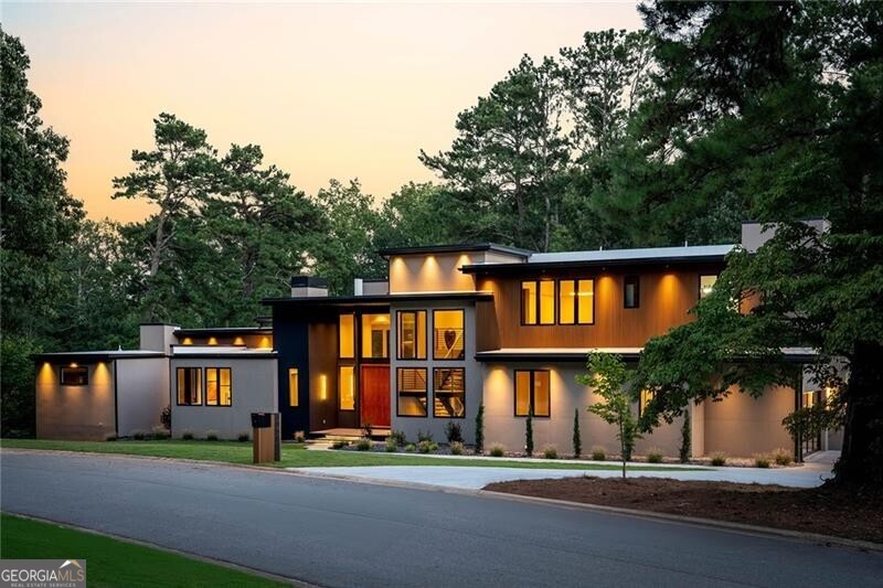 Situated within the prestigious Indian Hills Country Club and located in the highly sought-after Walton High School district, this exceptional modern residence epitomizes luxury and sophistication. Set on a premier golf-front cul-de-sac lot with sweeping views, this home offers three impeccably finished levels of bespoke craftsmanship and an unparalleled amenity package, catering to the most discerning of buyers. The main level is a masterclass in open-concept living, with soaring ceilings and wide plank oak flooring that accentuate the grandeur of the space. The dramatic fireside family room, complete with a cocktail seating area and wet bar, is an entertainer's paradise. The state-of-the-art kitchen features exquisite two-tone cabinetry, waterfall countertops, and a SubZero and Wolf appliance package, including separate refrigerator and freezer columns. Adjacent to the kitchen is a fully equipped scullery, outfitted with a suite of professional-grade appliances-refrigerator, oven, stove, dishwasher, and ample cabinetry-designed to cater to every culinary need. The main level's primary suite is a true retreat, offering a morning bar and a spa-inspired bathroom adorned with large-format tile flooring, a walk-in wet room featuring an oversized shower and floating soaking tub, dual vanities, a make-up counter, dual water closets, and a beautifully custom-designed closet. Completing the main level are a glass-enclosed office, an opulent guest suite with an ensuite bathroom, a formal powder room, a well-appointed laundry room, and a dedicated pool bathroom. A striking wall of nano accordion doors seamlessly extends the living space to a covered fireside veranda and an infinity-edge saltwater pool and spa, all overlooking the tranquil golf course. Upstairs, luxury continues with four ensuite bedrooms, a grand fireside bonus room, and a spacious rooftop terrace perfect for al fresco gatherings. The upper level also includes an additional laundry room and a powder room, ensuring convenience at every turn. The fully finished terrace level is a haven for entertaining, featuring an open-concept media room, glass-enclosed gym, fully equipped sports bar, lounge, family room, powder room, and a guest suite, all designed with the same meticulous attention to detail found throughout the home. Further enhancing the residence are the conveniences of a three-stop elevator and a three-car garage. This home is more than just a place to live-it is a statement of refined living, designed for those who demand the extraordinary, set in one of the most coveted locations within the esteemed Indian Hills community.