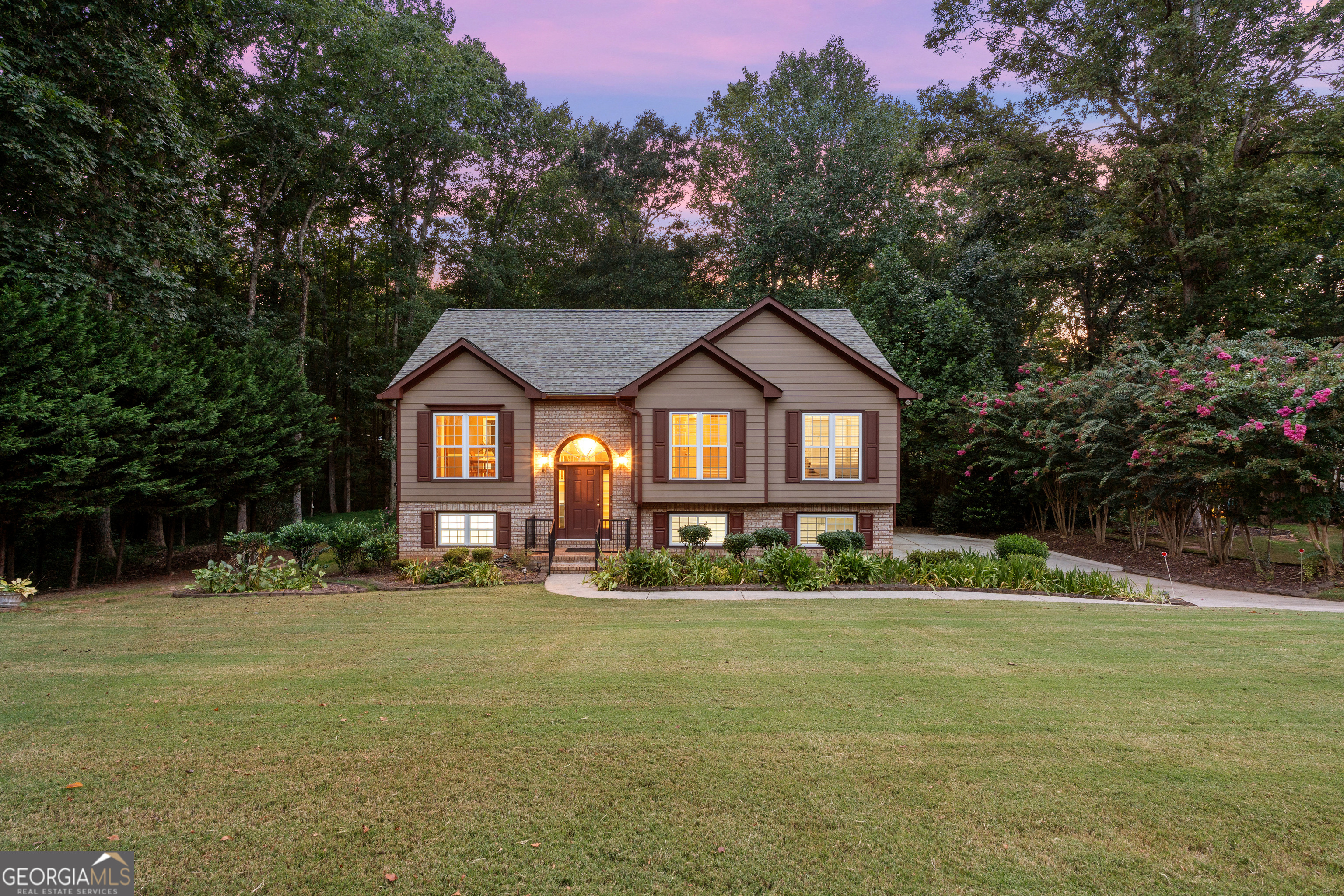 Welcome to 2610 Misty Hollow Lane, an immaculately cared-for, one-owner home in a beautiful Forsyth County neighborhood. This split-level property offers 4 bedrooms, 3 full baths, and a layout designed for everyday living. Home Highlights * Freshly painted siding for a modern, updated look. Lush landscaping. * Spacious primary suite with large walk-in closet, double vanity, soaking tub, and separate shower * Deck rebuilt with Tech Deck materials, with stairs to access the expansive back yard * Extended concrete pad providing extra parking and easy access to the rear of the home * New water heater for peace of mind Inside, you'll find versatile spaces including a bonus room ideal for a home office, playroom, or guest suite. The oversized primary suite is a private retreat, while the main living areas flow comfortably for both daily life and entertaining. Step outside to enjoy evenings on the updated deck or gatherings in the spacious backyard. The extended driveway and 2-car garage with storage make hosting easy. Located in a sought-after Forsyth County community, this home combines updates, space, and a prime location. With top-rated schools, shopping, dining, and commuter routes nearby, it's the perfect balance of convenience and neighborhood charm.