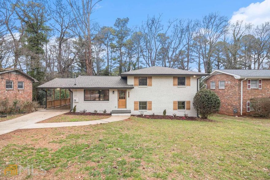 Gorgeous four-sided brick split-level has been completely renovated and reimagined! Walls were removed to create an open and entertaining floorplan between the kitchen, living room, and dining room. Fabulous high-end kitchen has all new soft-close cabinets with pantry, large island with seating for 4, quartz countertops, Whirlpool stainless steel appliance package, and tile backsplash. Massive primary suite on the lower level has enough space for a bedroom and sitting area with a decorative fireplace, giant walk-in closet, and an ensuite bath featuring a soaking tub, double sink vanity, quartz counters, walk-in shower with frameless glass, and linen closet. Two additional full baths have all-new tile, tubs, vanities, toilets, and fixtures. New and refinished real oak hardwoods throughout all levels. Large laundry room and plenty of storage throughout the home. The exterior features 2 brand new decks - one off the open living/dining/kitchen space on the main level, and one off the primary suite on the lower level. Full privacy fenced yard is ready for pets and family gatherings. Covered parking in the carport with driveway parking for at least 3 additional cars. Super convenient to I-285 and an easy walk to the local schools.