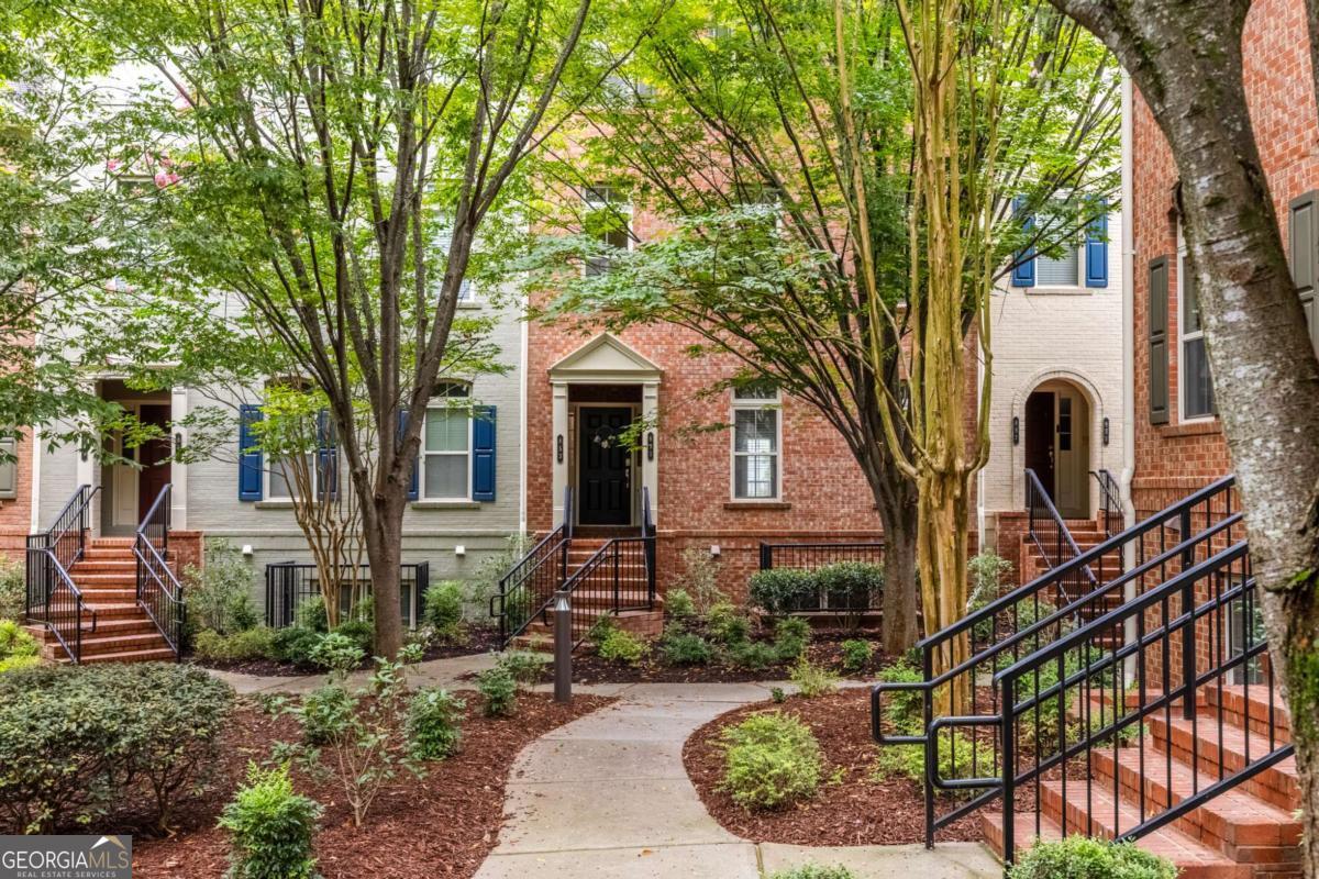 Meticulously maintained brick 3-story condo in the heart of Sandy Springs. This spacious unit lives like a townhome and features oak hardwood floors, a fireside living room with built-ins, private balcony, and additional family room that overlooks a verdant courtyard. The well-appointed kitchen opens to the living room and dining room; you'll love the granite countertops, stainless steel appliances, breakfast bar, and two pantry closets. Off the family room, a hallway bar and powder room for guests offers maximum convenience. This home has great flow-the upstairs has 2 large secondary bedrooms and a generous primary suite that is the perfect retreat. The primary includes beautiful tray ceilings, a roomy walk-in closet, and tiled bath with double vanities, separate shower, and soaking tub. Two secondary bedrooms receive ample natural light and have plentiful closet space. The upstairs includes a conveniently located laundry area and linen storage. This home also features a single-car garage with storage shelves and closet, and the owner has replaced the HVAC. Promenade at Northplace is a well-maintained community of 102 homes and the most affordable newer-built community in Sandy Springs. Built in 2008, the HOA has great value and includes pool, natural gas, sanitation, termite, and exterior maintenance (including the roof!). New to Sandy Springs? This perfectly placed home straddles the Dunwoody and Sandy Springs line, so you get the best of both worlds! Enjoy the eats at Politan Row, unwind at City Springs for an outdoor concert, enjoy farm-fresh foods at the neighborhood farmer's market, and make travel and commuting a piece of cake by using MARTA. You'll love how conveniently located this home is to transit, shopping, dining, HWY 400 & 285, and everything the Sandy Springs/Perimeter area has to offer. Zoned for coveted Woodland Elementary, Sandy Springs Middle, and North Springs High School.