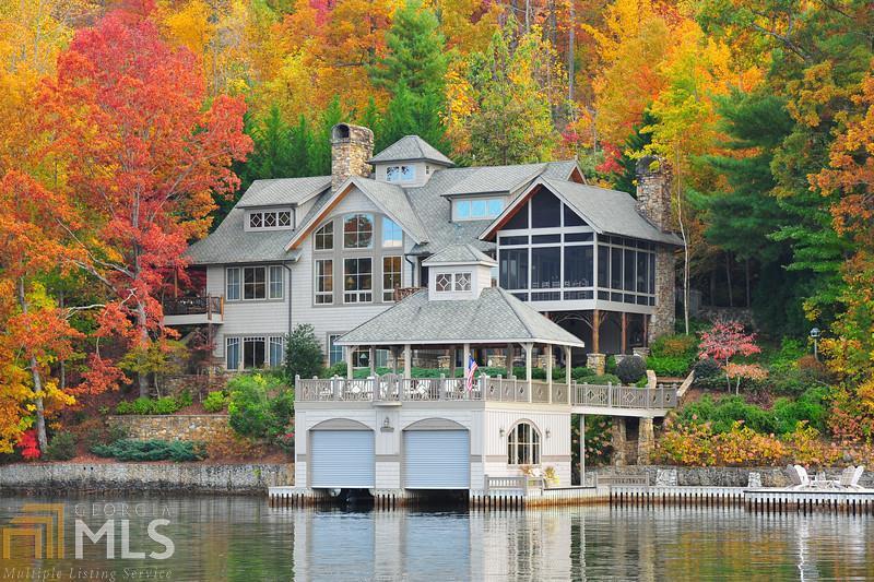 Fall in love with the stunning mountain and sunset views from this romantic 5 BD, 5.5ba luxury getaway on Lake Burton. The open floor plan features hardwood floors, custom laurel railings, vaulted ceilings, a grand stone fireplace, floor to ceiling windows and reclaimed barn wood timbers. A beautiful screened porch offers big water views, a stone fireplace with sitting area plus dining for 10+. Additional features include a terrace level rec room, private balconies, wine cellar and 2 car garage.