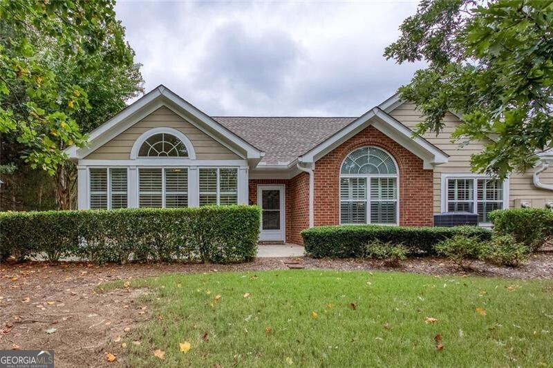 Welcome to one of Marietta's most sought-after senior communities, where timeless design and active adult living come together in a setting built for connection, comfort, and ease. This four-sided brick condo offers low-maintenance luxury with hardwood floors throughout the main areas and one of the best locations in the neighborhood-tucked quietly away with views of open green space, yet just moments from the action. Step inside and you're greeted by a light-filled, spacious living area, perfect for entertaining or simply enjoying a peaceful afternoon. Large windows frame the scenic backyard while the private patio offers a serene spot to sip coffee, read, or catch up with neighbors. The kitchen is thoughtfully laid out with modern appliances and opens seamlessly into the dining area-ideal for everyday meals or gathering with friends. Every inch of this home is designed with simplicity and function in mind. The two generously sized bedrooms offer comfort and privacy, with the primary suite featuring an en-suite bath. A second full bathroom serves guests or a home office with ease. You'll also find a flexible den-perfect for hobbies, reading, or extra storage-and a sunroom that invites you to relax and enjoy year-round views of the beautifully landscaped grounds. But what truly sets this property apart is the lifestyle. As a resident, you'll enjoy access to exceptional amenities including a clubhouse, pool, library, fitness center, and community events designed to bring neighbors together. Still, the greatest amenity of all is the vibrant, welcoming community-a place where friendships are easy, support is close by, and life feels fuller. Located just minutes from shopping, dining, healthcare, and interstate access, this condo is ideal for anyone seeking a peaceful retreat with all the right connections. Ready to embrace a more relaxed, connected, and enriching way of life? Schedule your private tour today and experience the best of 55+ living in Marietta.