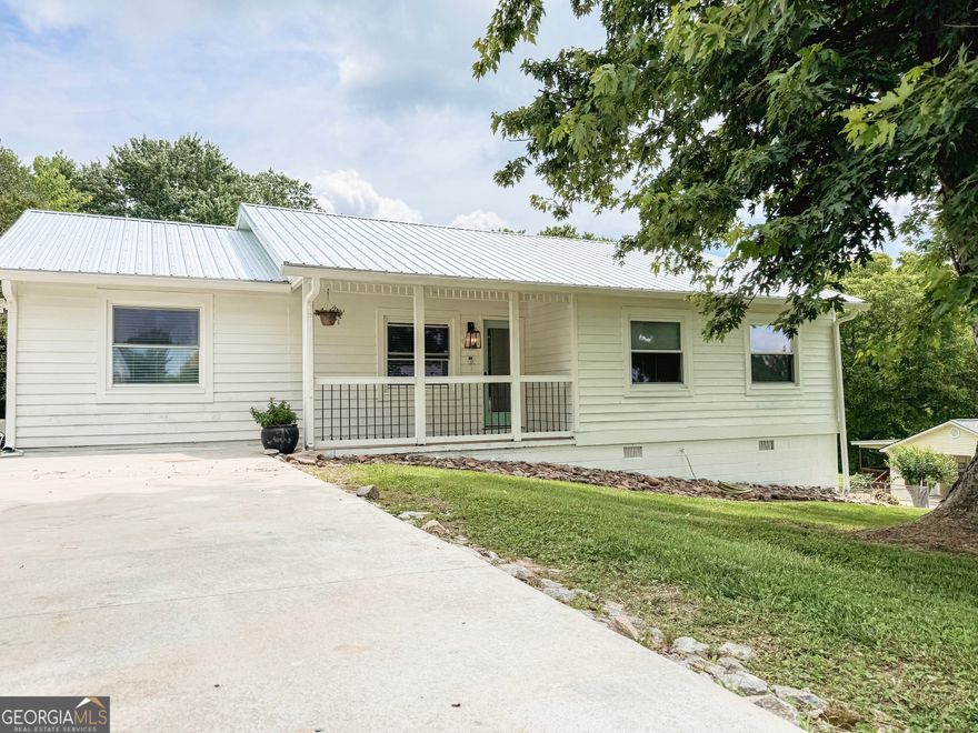 Beautiful updated ranch home with stainless steel appliances, hardwood floors throughout, a composite back deck that overlooks an oversized fenced yard with mature trees. 3 bedrooms and 2 full baths. Primary bath has a brand new tiled shower. Primary bed features a large window overlooking the backyard. Freshly painted exterior. New metal roof (Fall 2024) and large parking area with enough room for a RV or boat. No HOA. This home is truly a little gem in south Hall. Golf courses, boat ramps, restaurants, parks, and more all within 10 minutes. 5 minutes to the interstate and only 45 minutes from Atlanta.