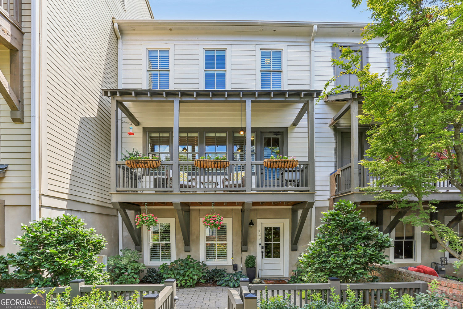 Just down the pebble path and under the arched brick arbor, enter the garden gate and surround yourself with a lush master gardener's perennial patio entry to this immaculate, move-in ready townhome. Ideal for new owners seeking a lock & leave lifestyle within walking distance to Marietta Square, this move-in ready, and fully renovated home, tucked in the quiet interior of the Manget Community, is a once in a lifetime opportunity. Solid, charming, VERY gently used and extremely well-maintained, this home features high ceilings, site-finished hardwood floors, a Chef's Kitchen with all stainless KitchenAid appliances, an oversized granite island with bar seating, an open floor plan to the gorgeous sun drenched fireside great room, and upgraded features & fixtures throughout. The full-sized dining room - also bathed in natural light - overlooks a spacious deck with the landscaped community courtyard as an ideal backdrop to dinners in and effortless entertaining. The Owner's Suite is a sanctuary of its own, with soaring ceilings, abundant light and ample space for oversized furnishings or a cozy sitting area. The primary bath is equally as spacious with a double vanity, soaking tub, private water closet, and a spa-like tiled shower with frameless enclosure. The primary walk-in closet is endless. Two sizable secondary bedrooms each have their own ensuite baths. Plantation shutters, updated lighting, a 2-car garage, and loads of storage round out the unique features. Upscale updates galore, including Fresh Paint Inside & Out, New Roof, New HVAC, Ring Cameras, Schlage Locks, and so much more! No detail has been left untouched. Short walk to upscale and casual dining, shopping, breweries, antiquing, live theatre, movies, weekend farmers markets, Marietta Food Market, Glover Park, grocery stores and more. Easy access to Hwy 41 and I-75. Nearby hiking at Kennesaw Mountain National Battlefield Park. This is a must-see quality home!