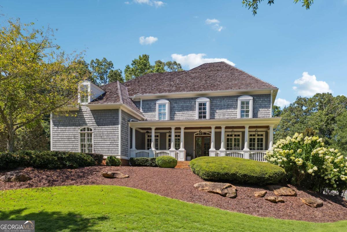 Originally crafted by renowned builder Steve Powell, this timeless Cape Cod-style residence is set within one of Milton's most prestigious and intimate neighborhoods-just 10 minutes from Downtown Crabapple, Alpharetta, and GA-400-offering an exceptional blend of elegance, privacy, and convenience.. Beautifully reimagined with a professionally designed remodel, the home features white oak floors with a soft white country stain throughout, curated lighting, designer wallpaper, and soft arch doorways that lend an air of quiet sophistication. The sun-drenched interiors boast lush green views from every room, inviting the outdoors in and creating a serene, natural backdrop throughout. The heart of the home is a chef's kitchen featuring Mykonos quartzite countertops, high-end appliances, and a fully custom butler's pantry-all with direct sightlines to the backyard and pool area from the kitchen, main floor, and much of the second level. A new roof, fully replaced just 4 years ago, adds lasting peace of mind. The spacious primary suite offers a serene retreat, while the finished walkout basement with stained concrete floors provides endless possibilities for recreation or relaxation. Thoughtful features like a newly updated mudroom, two laundry rooms, and a fully integrated alarm system make everyday living effortless. Outside, discover your own private oasis: a new heated saltwater pool and spa wrapped in full-color bluestone, a covered porch with outdoor fireplace, and a dedicated space plumbed for your dream outdoor kitchen. Two walkout-accessible yards-a backyard and a side yard-provide ample space for entertaining, play, or gardening, supported by a new full-yard irrigation system. With a 4-car garage, stunning design, and zoning for Milton's top-ranked schools, this home offers the rare combination of timeless craftsmanship and modern comfort. Cape Cod charm meets refined modern living-welcome to Crabapple Estates.
