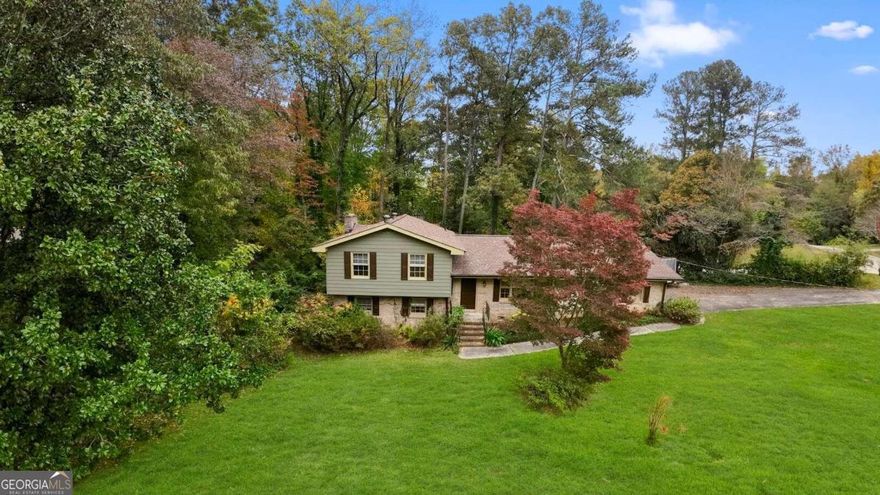 **Perfect for a handy owner-occupant or purchase with a renovation loan**    Envision yourself in this spacious 4-bedroom, 2-bathroom split-level home, designed for both relaxation and entertaining. Step into a cozy living room featuring a charming fireplace, perfect for gathering on cool evenings. The kitchen is updated with sleek granite countertops, offering plenty of space for meal prep and casual dining.    Outside, enjoy a large deck overlooking a generous lot-ideal for entertaining friends and family or unwinding in a peaceful setting. The primary suite boasts a double vanity for added convenience, while all bedrooms provide ample space and comfort.     Located just minutes from shopping, dining, and the East-West Connector, this home combines tranquility with easy access to all the essentials. Make this your next home and enjoy the perfect blend of comfort and convenience!      "Buyer offered $1000 credit at closing with the use of the seller's preferred lender!"