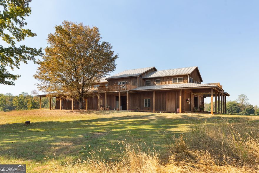 Stoney Creek Ranch a 363-Acre Working Ranch in North Monroe County, Georgia. Out here in North Monroe County, where the rolling hills meet the Georgia sky, lies 363 acres of something rare. Wide-open pastures, spring-fed creeks, and sunsets that paint the horizon in fire. This is more than land - it's a way of life.  The Land 363 total acres, with over 220 acres of improved pasture (Bermuda and  endophyte-free fescue).   Fully cross-fenced with high-tensile New Zealand-style electric fencing, designed for efficient herd rotation and easy management.   Each pasture features catch pens and large, virtually indestructible 12-foot industrial tire water troughs.   Four active wells supply abundant fresh water across the property.   Elevations range from 550' to 700', offering rolling hills and sweeping views - you can see all the way to Jackson from the back porch.   Two year-round, spring-fed creeks, plus a northern boundary creek flowing toward the Ocmulgee River, only six miles away.   Rich habitat for whitetail deer, turkey, dove, and abundant native wildlife.  Equestrian & Livestock Facilities  This ranch was built with purpose - designed for both horsemen and cattlemen:   90' x 80' hay and utility barn with enclosed 20' x 12' shop.   Covered 60' oilfield-pipe round corral, 150' pipe round corral, and a 200' x 120' arena (130' x 120' covered).   Six covered stalls, with additional outside stalls and paddocks.    20' x 20' tack room and 12' x 16' storage building.   Caretaker's apartment with kitchen and full bath.   Heavy-duty working cattle pens with hydraulic chute and telephone pole/pipe fencing. Every detail supports smooth operations - from rotational grazing to sorting, doctoring,  and working livestock.  The Home  At the heart of the ranch sits a 7,000+ sq. ft. barndominium, rugged on the outside and refined  within:   Upstairs (approx. 3,500 sq. ft.): Spacious main living quarters with 3 porches, including a covered back porch overlooking the hills.   6 bedrooms, 3 full baths upstairs, including a private master suite with study, walk-in closet, and ensuite bath.   Open-concept kitchen and living room, centered by a wood-burning stove - the heart of the home.   Custom touches throughout: white pine ceilings, Douglas fir wainscoting, heart pine cabinets.   Commercial-grade gas oven and range, nickel farmhouse sink, Bosch dishwasher, stainless appliances, and a walk-in pantry.   Additional features: subzero wine cooler, refrigerated drawers, dual dishwashers, and a utility/laundry room with storage.  Downstairs (approx. 3,500 sq. ft.) offers versatility:   Second kitchen, full bath, laundry, freezer/storage room.   Workout room, two studio/recording spaces (14' x 28' each), bunk room for guests, and more.  Location & Lifestyle     60 minutes from Atlanta, 40 minutes from Macon, and just 50 miles from Hartsfield-Jackson International Airport.   Minutes from Indian Springs State Park and Juliette, Georgia - home of the Whistle Stop Cafe, made famous by Fried Green Tomatoes.   Surrounded by recreation: hunting, fishing, horseback riding, and ATV trails. Within reach of Piedmont & Oconee National Forests, Lake Oconee, and Lake Sinclair.   Close to historic towns: Forsyth, Monticello, Jackson, Barnesville.  Why This Ranch  Whether you're looking for a performance horse facility, a cattle operation, a private retreat, or an investment with agricultural income potential, this ranch delivers. With fiberoptic internet, abundant water, and a private mile-long drive, it offers both seclusion and convenience.  This is more than a ranch. It's a western dream, rooted deep in Georgia soil.    Schedule your private showing today.