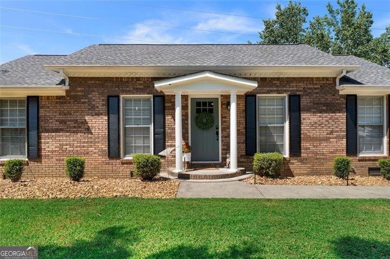 Welcome home to this beautifully remodeled four sided brick ranch perfectly situated on 2.25 private acres just minutes from town. This open-concept home features 3 bedrooms, 2 full baths, and stunning updates throughout. Step inside to find a brand-new kitchen with new cabinets, countertops, and appliances, seamlessly flowing into the spacious living and dining areas. LVP flooring runs throughout the home for a clean, modern look. The primary suite is a true retreat with a large tiled shower, custom-built closet, and an updated bathroom designed for comfort and style. The secondary bathroom has also been beautifully updated. Enjoy outdoor living with a covered back patio overlooking the partially fenced backyard-ideal for pets, entertaining, or relaxing. The property also includes a separate building for lawn equipment/storage and a covered carport for convenient parking. Move-in ready and sitting on a generous lot, this home offers the best of both worlds-peaceful country living with close-to-town convenience.