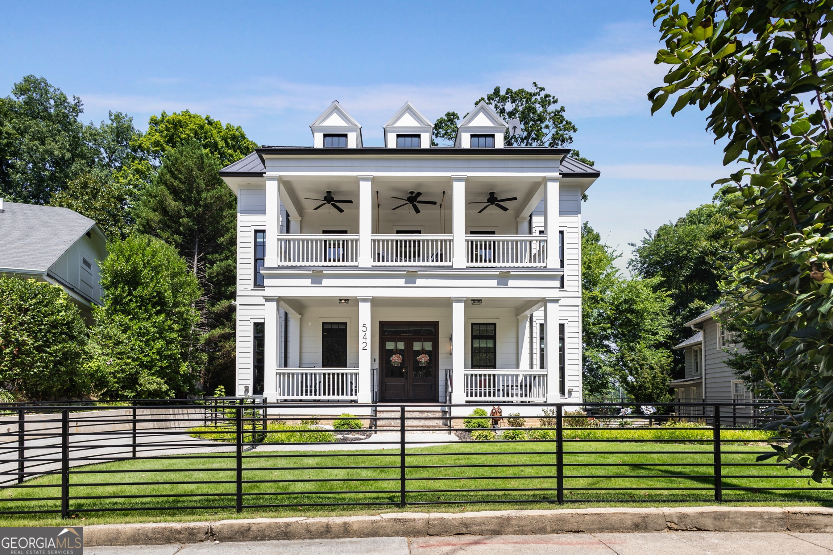 Experience the pinnacle of urban luxury and lifestyle in this 2022 custom-built Virginia Highland masterpiece, crafted by renowned luxury builder Evercraft. Situated on a rare very private and double-sized lot (.53 acres), this home offers unparalleled access to Atlanta's iconic Piedmont Park, the Beltline, and the Botanical Garden. Immerse yourself in the vibrant energy of the city with art festivals, farmers markets, concerts, and athletic activities right outside your door. You will find premier dining, shopping, gyms, and theaters a short stroll away in Midtown or Virginia Highland. This home epitomizes the convenience of intown living. Every inch of this four-level residence is designed to celebrate modern sophistication and comfortable living. The front and back yards are fenced and professionally landscaped, with an automatic gate providing both privacy and convenience. Host unforgettable rooftop gatherings with panoramic views of the Midtown and Buckhead skylines, relax on the screened porch, or swing your cares away on the front porch bed. The main level welcomes you with a formal foyer, an open-concept chef's kitchen with a walk-in pantry and beverage bar, a formal office, and a guest bedroom with an ensuite bath. The living area, complete with a cozy fireplace, flows seamlessly to outdoor entertaining spaces. Upstairs, the third floor is a private haven featuring a luxurious owner's suite and three additional en-suite bedrooms, a laundry room, and a front porch perfect for quiet moments. The lower level is an entertainer's dream, boasting a second fireplace, a kitchenette, a gym, and ample recreation space. The top floor offers versatility with a second office or lounge, opening to the rooftop deck with skyline views. With four-car garage parking, ample extra guest parking, EV charging, and an elevator connecting all levels, this home offers unmatched convenience and functionality. Built for those who cherish walkability, elegance, and the vibrancy of Atlanta's urban core, this residence is more than a home it's a lifestyle.