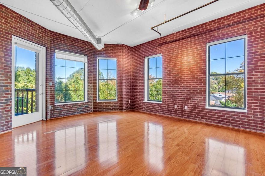 This sun-drenched and inviting loft is the one you have been waiting for! Featuring classic exposed brick walls, beautiful hardwood floors, and relaxing views of both lush trees and Midtown Atlanta-the views are enjoyable from inside or from your spacious private patio. Many things make this loft special, and one is that it offers a true bedroom with floor-to-ceiling walls, a large closet, and an en-suite bathroom. Need more space? The versatile flex area, complete with its own large closet and a custom folding wall for privacy, is perfect for a second bedroom, home office, dining room, or creative studio-tailored to your lifestyle---and right next to a second full bathroom! The kitchen is both stylish and functional as it opens to the living spaces, with wood cabinets that complement the loft's red brick accents. Your deeded, garage parking spot (and overflow spots are also available for friends and family visiting), means you can leave the car behind and embrace the live-work-play lifestyle at Central Park Place, an exclusive residence with only five units per floor. Step outside to Central Park for tennis, basketball, soccer, or simply relax in the green spaces. Savor music and food festivals in the warmer months, and explore nearby gems like Freedom Park PATH Trail (connecting you to the Beltline), Ponce City Market, Old 4th Ward Park, Piedmont Park, MARTA, and all the excitement Midtown has to offer. The monthly HOA fee covers manicured grounds, clean shared spaces, a fitness center, dry sauna, and essential utilities including gas, water, trash, and termite control. Google Fiber gigabit internet is available in the building as well! The community replaced the roof in 2024, which has already been paid for by current residents. This condo is investor friendly and RENTAL PERMITS ARE CURRENTLY AVAILABLE! This is more than a loft. It's your gateway to Atlanta's most dynamic lifestyle, where you can enjoy the best Atlanta has to offer and then come home to a serene home among the treetops.