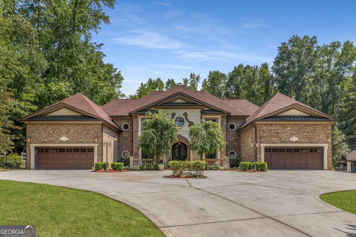 Refined luxury meets resort-style living in this extraordinary 6-bedroom, 5.5-bath European style estate, set on nearly five private acres in the heart of Smyrna. Offering close to 7,000 square feet of beautifully designed living space, this home is the perfect blend of elegance, comfort, and functionality. With a newer roof and a spacious four car garage, the property has been meticulously maintained and thoughtfully upgraded throughout. From the moment you step inside, you're welcomed by a grand chisel stone arch hallway and a dramatic spiral staircase that immediately sets the tone for the craftsmanship and detail that define the home. Imported Italian tile flows underfoot, leading you into the heart of the home a custom-designed chefs kitchen featuring a large island with counter seating, prep sink, custom cabinetry, and stainless steel appliances. The kitchen opens into an inviting informal dining space with a built-in bar, creating an ideal layout for entertaining and everyday living. The main level also features a bright and airy living room filled with natural light, a formal dining room, a cozy great room, a laundry closet, a versatile multi-use room, and a private bedroom with ensuite bath perfectly suited for a nanny suite, in-law suite, or guest accommodations. Movie nights are elevated in the private, theater-style media room, complete with surround sound, a projector, and tiered seating for the ultimate in-home cinema experience. Just beyond the living spaces, step out into your own personal backyard resort. Lush, manicured landscaping surrounds the saltwater pool, jacuzzi, covered outdoor fireplace, firepit, and basketball court offering endless opportunities for relaxation, entertaining, and recreation. Upstairs, the expansive owner's suite is a true sanctuary. Vaulted ceilings and large windows create an open and serene environment, while the luxurious en-suite bath features a soaker tub, walk-in shower, and an oversized custom closet. The suite also includes a fully equipped private gym, providing a convenient and motivating space to stay active without leaving home. Additional highlights include a Control4 whole home audio/video system and integrated smart home technology throughout. Ideally located just minutes from shopping, dining, and major highways, this exceptional estate offers a rare opportunity to own a private retreat in one of Smyrna's most desirable areas. Every detail has been considered this home is truly one of a kind. Situated just minutes from The Battery, Truist Park, Downtown Smyrna, Vinings, and major highways