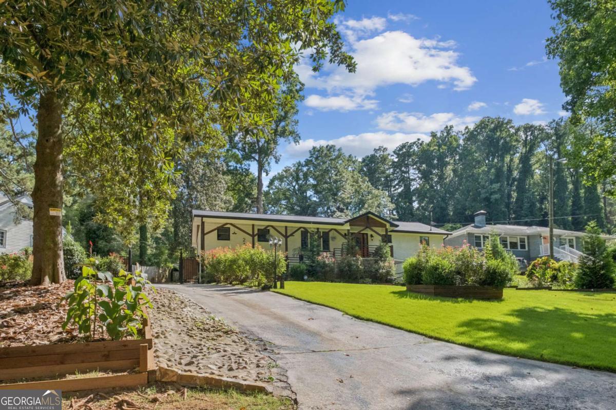 Beautifully Maintained 4-Sided Brick Home in Prime Atlanta Location! This spacious residence offers 4 beds and 2 baths on the main level, plus a fully finished 3 bed/2 bath guest suite on the lower level - perfect for a growing family or potential rental income. Step into the inviting open floor plan featuring hardwood floors throughout and a large entry foyer. The main kitchen is upgraded with granite countertops, stainless steel appliances, and a center island, ideal for entertaining. The oversized primary suite boasts a jacuzzi tub and double vanity. Secondary bedrooms are generously sized. The lower-level guest suite mirrors the upper with an open-concept layout, full kitchen with granite counters and stainless steel appliances, and updated finishes throughout. Enjoy outdoor living with a rear deck, patio, and a fully fenced, expansive yard - perfect for gatherings. Additional features include upgraded gutters and a converted carport offering additional living space. Don't miss this incredible opportunity!