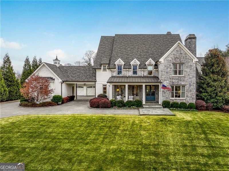 No detail was overlooked in this stunning custom-built Milton home, formerly owned by Hall of Fame pitcher Tom Glavine, and located in the coveted Hayfield neighborhood. The open kitchen with double islands flows into the family room with a beautiful Francois limestone fireplace, while the bright sunroom provides the perfect spot to unwind. The spacious master suite on the main level includes double vanities, a large walk-in shower, a soaking tub, and his-and-hers walk-in closets, creating a true retreat. Upstairs features three large bedrooms with ensuite bathrooms, plus a bonus room and a second laundry room. The terrace level is an entertainer's dream, complete with a wet bar, theater room with a Trackman golf simulator, and two separate gyms. Outside, the private, walk-out backyard includes a heated saltwater pool, two putting greens, and a built-in grill and bar. Recent updates like whole-house automation and refreshed interiors ensure this home is move-in ready.