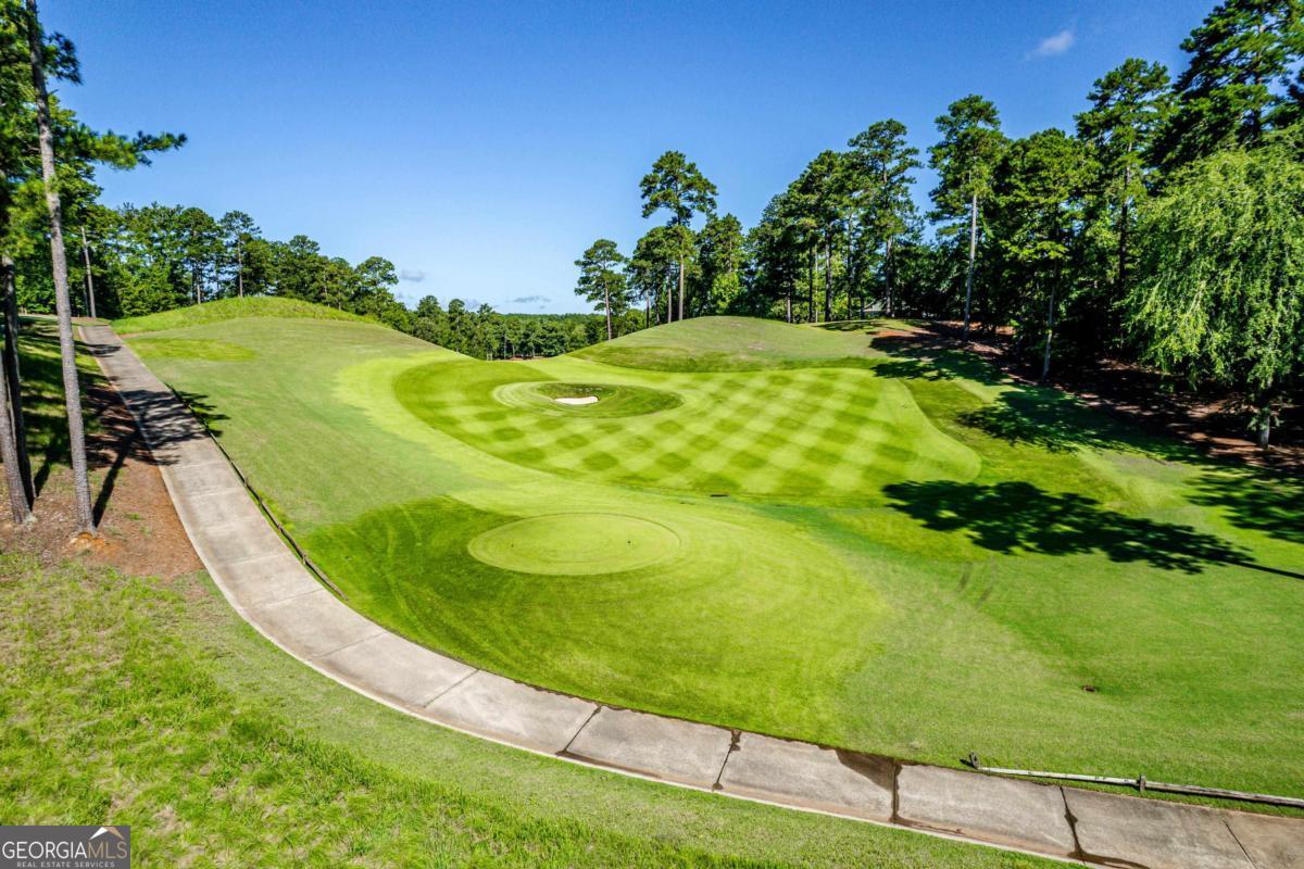 PRIME GOLF HOMESITE AT REYNOLDS LAKE OCONEE Nestled in the admired Sandy Ford area of Reynolds Lake Oconee, this special homesite offers a unique opportunity to build your dream terrace-level home on .74 acres of prime real estate. Situated on the #14 tee box of the coveted Creek Club golf course, this lot provides breathtaking views that will delight any golf enthusiast. The serene surroundings and lush greenery make it an ideal location for those seeking tranquility and luxury. As an added benefit, the seller is making a golf membership available, ensuring exclusive access to one of the most sought-after golf communities in the region. Whether you envision a private retreat or a vibrant family home, this homesite offers the perfect canvas to create a masterpiece that complements its stunning natural setting. Don't miss this rare chance to own a piece of paradise in Reynolds Lake Oconee.
