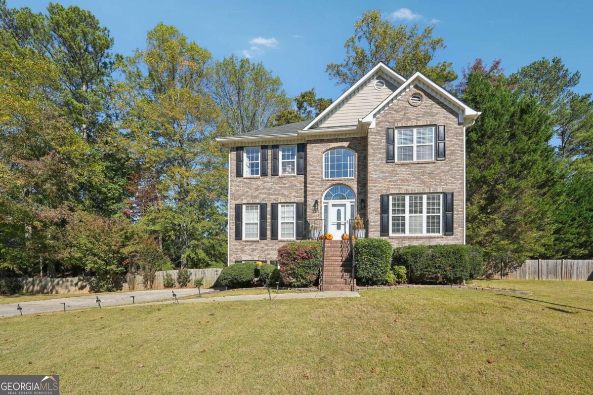Welcome to this stately brick front home that has tons of upgrades and light filled spaces in beautiful Cheatham Lakes! Step inside to a soaring 2-story foyer and hardwood floors throughout the entire main level. A formal dining room with chair railing to the left is the perfect place to entertain, while a formal living room with barn door entry to the right is a great space to cozy up with your favorite book or set up your home office. The bright open concept living room has loads of natural light and private wooded views as well as a cozy stacked stone fireplace perfect place to gather around a fire on a chilly Georgia evening. Enjoy a gourmet kitchen with granite counters, breakfast bar, stainless steel appliances, tile backsplash, plenty of cabinet and counter space, and a light filled dining room. The spacious laundry room close by has a sink for added convenience. Upstairs, retreat to the primary bedroom with tray ceiling and gorgeous renovated en-suite bath with dual sinks and a wet room shower and tub - fully tiled, several showerheads, fixed frame shower, and pedestal soaking tub! Three spacious secondary bedrooms and a full bath ensure room for everyone. Don't miss the partially finished basement with 2 large rooms to spread out - make this your dream man cave, craft room, playroom, guest/MIL suite - you name it! A full bath and a bedroom complete the level and with outdoor access, everyone can come and go as they please. Fully fenced backyard has plenty of room to enjoy with mature trees, an extra large upstairs deck with room for multiple seating areas as well as a covered patio below. Home includes a workshop! Updates include primary bath, new bath flooring in secondary bath upstairs, basement level, and a newly built retaining wall in the backyard. The community has a lake, playground, trails and is conveniently located to shopping, restaurants, parks and Lake Acworth for all your boating and fishing needs. With great Cobb schools this one checks all the boxes. Don't miss the opportunity to make this one your own! Schedule your tour today!