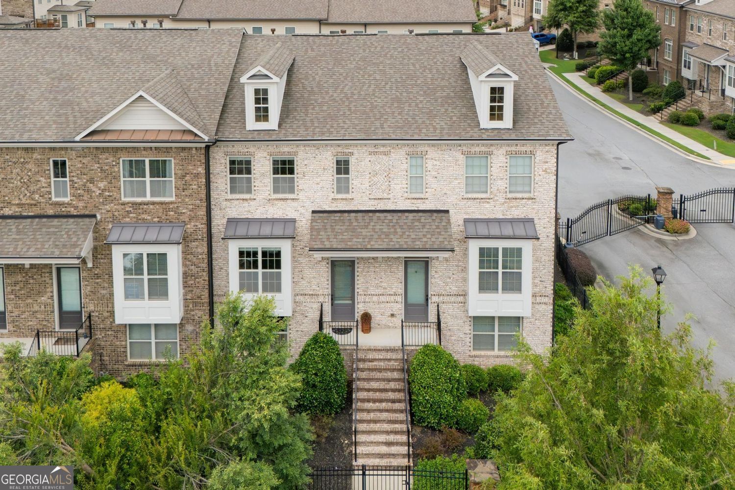 LOCATION! LUXURY! LIFESTYLE! Drenched in natural light across all three levels, this luxury Alpharetta townhome blends sophisticated upgrades with a flexible and functional layout. Located just perfectly between Alpharetta and Roswell among top-rated Fulton County schools, the home offers both elegance and convenience. Upon entering from the garage, a versatile full en suite bedroom awaits-ideal as a private guest retreat, home office, or fitness space. Experience the main level through the charming front entry as it unfolds into a sunlit, open-concept living and dining area. The showpiece kitchen boasts pristine white cabinetry, soft grey stone countertops, and a seamless flow perfect for both everyday living and hosting friends. An additional office alcove or reading nook overlooks the inviting deck. A striking stone-accented fireplace is framed by custom built-ins topped with sleek granite, creating an exciting focal point that instantly elevates the home's entertainment space. Upstairs, a convenient laundry room and two spacious bedrooms with bathrooms await, including the luxurious primary suite with a spa-inspired bathroom and a meticulously organized walk-in closet. Enjoy the neighborhood's best location-front-facing, unobstructed views, and direct access to generous guest parking. Offered with the option to include furnishings for a truly turnkey, move-in-ready experience, this stunning townhome is not to be missed!