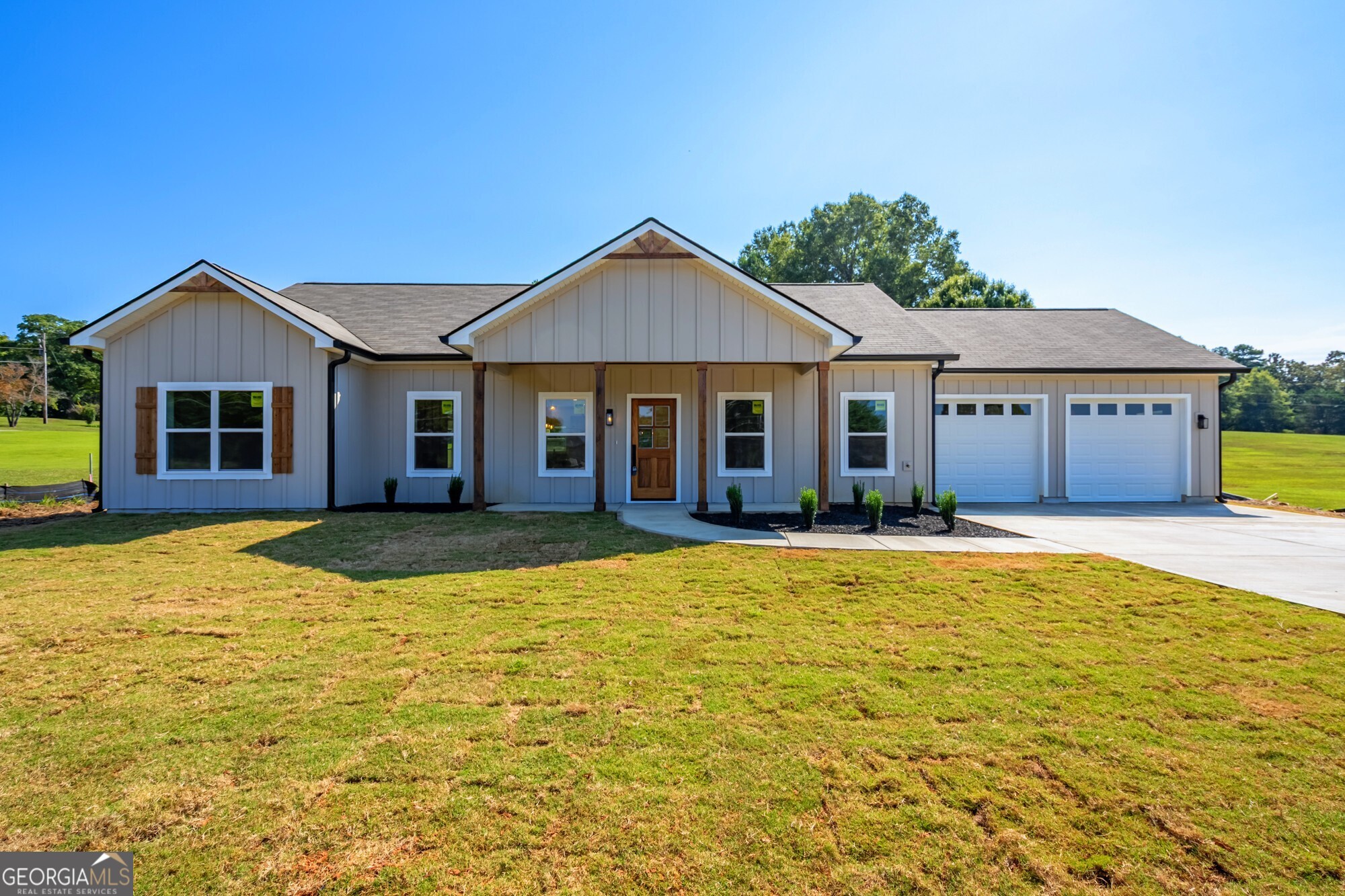 Located just minutes from schools, shopping, dining, Polk Medical Center, and with easy access to Highway 27 and 278, this beautiful new construction home offers luxury living in a peaceful cul-de-sac setting with a rural feel. Step inside to discover high-end finishes throughout, including a dramatic 12-foot vaulted ceiling with a floor-to-ceiling custom fireplace, 9-foot ceilings throughout the rest of the home and custom real wood cabinetry paired with elegant quartz countertops. The open-concept floor plan is perfect for both daily living and entertaining, with the master suite thoughtfully positioned opposite the secondary bedrooms for added privacy. Luxury Vinyl flooring throughout including in the master, with tile floors in bathrooms and tiled showers. The spa-like master bathroom features a free-standing tub, glass-enclosed tile shower, and a spacious walk-in closet. The chef's kitchen is fully equipped with stainless steel appliances, a 6-foot island, soft-close cabinets, tile backsplash, and a kitchen sink window offering a stunning view of the wooded backyard. Enjoy meals or entertain in style with double mahogany doors that open from the dining area to the serene forest view. With a nearly 200-foot setback from the street, the expansive front yard and long driveway create a grand first impression. The back of the property has an almost 500-foot x 12-foot-wide strip ready for any of your outdoor adventures, hiking trail, ATV trail or just enjoying the view! An oversized garage offering 24 ft x 24 ft of space and 9-foot ceilings also offers room to store your off-road vehicles. This home qualifies for USDA, FHA, and VA financing with ZERO MONEY DOWN or down payment assistance options for qualified buyers. $500 incentive toward closing costs with preferred lender. Seller is contributing up to $1,000 towards a home warranty and also providing a transferable termite warranty. Don't miss this opportunity to own a luxury home on acreage in a quiet, convenient location!