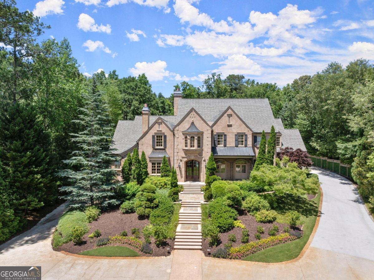 Situated on an incredible 2.2 acre gated estate lot in the heart of East Cobb directly outside of Atlanta Country Club, this custom home built by Steve Edison impresses with every turn. Pull in the winding driveway and through the incredibly manicured grounds into your Countryside villa in Provence. Every imaginable detail and custom feature is presented with unbelievable quality and finish. Step into the entry of the home and you are greeted with a two story foyer bordered by a stunning circular stair case (one of three stair cases up). Main level features: Spacious owners suite with enviable custom-built closets and recently renovated white marble bath perfectly located with inviting sitting area overlooking the 22x41 foot long pool and lush grounds. Library/office with fireplace and built in cabinetry, expansive dining room. Brand new kitchen with sleek cabinetry, integrated high end appliances (separate full size freezer and refrigerator), Neolith countertops with subtle veining and a spacious island work in tandem with the scullery and walk in pantry to create a chefCOs paradise. Two family gathering areas (fireplaces and built ins) and an additional office, three half baths, and large mudroom/laundry. Step upstairs to 5 spacious bedroom en-suites with expansive closet space and a bonus room. Perfect for entertaining, the living spaces continue on the terrace level which includes the 7th ensuite, incredible climate controlled wine cellar, handsome bar, theater, fitness studio and game room. Also walk out on terrace to 2 additional garages for a total of 6 garages ( 4 on main level). 6 fireplaces. The backyard is a show stopper with walk out level covered porch, stunning pool, playhouse, covered grilling and cooking area and fireplace, bath and plenty of flat level lawn. Outstanding space with functionality for today's lifestyle. Top rated schools of Sope Creek, Dickerson and Walton. Vacation every day at at 4351 Paper Mill Road.