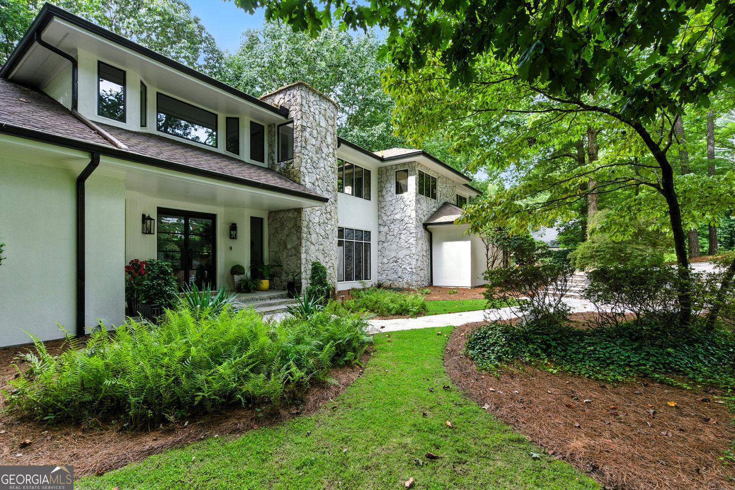 Renovated Contemporary Showpiece! Step inside to a dramatic two-story, two-sided fireplace that anchors the main living space, creating a stunning architectural centerpiece visible from the great room, music room and chic bar area. This completely move-in ready home offers the perfect blend of style, function, and is located in one of Atlanta's most coveted Inside-the-Perimeter neighborhoods-Glen Errol. This architectural gem blends sleek contemporary design with warm, inviting spaces, all framed by floor-to-ceiling windows that flood the home with natural light and showcase its wooded surroundings. The entertainer's kitchen is a true showstopper, featuring a massive island, custom cabinetry, and a hidden walk-in pantry, all opening to a cozy sunroom with its own fireplace--the perfect spot for morning coffee or after-dinner conversation. A formal dining room offers elegant space for special occasions. The main floor also features a versatile office/guest suite with a Murphy bed and a full bath-perfect for visitors or working from home. Upstairs you'll find a generously sized primary suite with huge walk-in closet and brand-new spa like bath as well as 3 more bedrooms and 2 fully renovated bathrooms, offering comfort and privacy for the entire family. A landing area overlooking the great room offers plenty of space for the entire family to hang out on the same level as the bedrooms. The terrace level offers a large living area, a sixth bedroom with half bath, and a vast amount of unfinished space, presenting endless possibilities for customization-think gym, media room, workshop, or additional storage. The backyard has not been developed yet but there is space to create your own oasis. Additional highlights include a 2-car garage with ample extra parking, updated lighting and finishes throughout. This home is a rare blend of modern sophistication and timeless comfort, all nestled in a quiet, tree-lined community just minutes from Buckhead, Sandy Springs, and major highways.