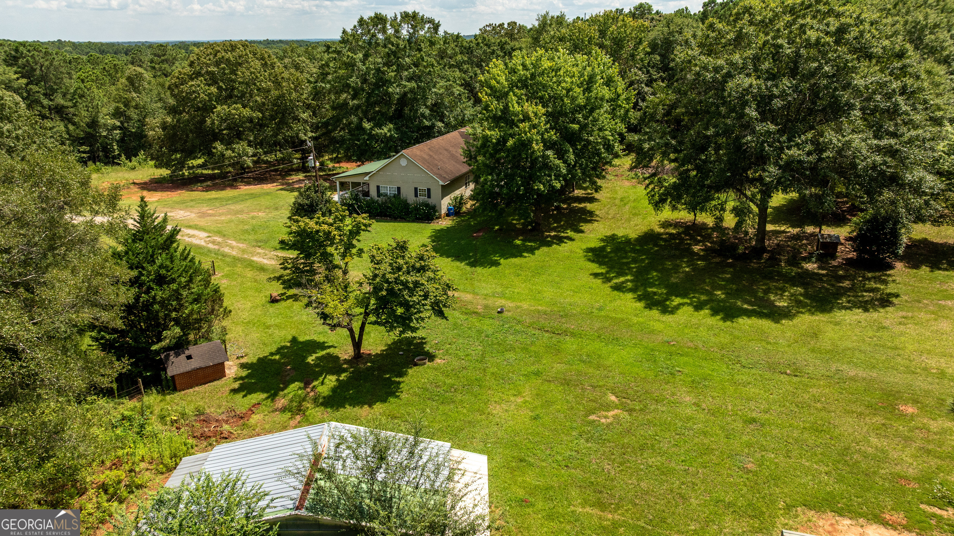 Welcome to 1730 Roland Road - Your Private Country Escape Just Minutes from the Flint River and Sprewell Bluff Park! This beautifully maintained stick-built home sits on an expansive and private piece of land, offering the perfect combination of peaceful seclusion and modern living. From the moment you turn into the driveway, you'll be welcomed by the sight of towering oak trees, fruit-bearing trees, and a large, open yard that feels like your very own slice of paradise. Whether you're watching deer wander through the woods or relaxing on the porch, this property is ideal for those seeking a slower pace and a deeper connection to nature. The home itself features a spacious and thoughtfully designed open floor plan that maximizes both light and functionality. The updated living room, dining area, and kitchen flow seamlessly together, making this home perfect for entertaining guests or simply enjoying quality time with family. You'll also appreciate the split-bedroom layout, which places the huge primary suite on one end of the home and the additional (very large) bedroom and office on the other, offering both privacy and comfort for everyone in the household. Inside, you'll find numerous upgrades throughout, including updated flooring, modern lighting, and a brand-new water heater. The kitchen is well-appointed with plenty of cabinet space and overlooks the main living area, so the cook never has to miss a moment. Each bedroom is spacious with ample closet space, and the bathrooms are bright and well-maintained. One of the standout features of this home is the extra-large rocking chair front porch that spans the entire length of the house--a true Southern staple! It's the perfect spot to enjoy your morning coffee, listen to the birds sing, or unwind in the evening as the sun sets over your land. Out back, a large barn offers even more value and versatility-ideal for equipment storage, hobbies, livestock, or workshop space. Whether you're an avid gardener, outdoorsman, or simply want room to roam, this property delivers. The electric gate is the cherry on top. Located just a short drive from the Flint River and Sprewell Bluff Park, outdoor recreation is never far away. Enjoy kayaking, hiking, fishing, and more--all within minutes of your front door. Despite its private setting, the home remains convenient to town, giving you the best of both worlds. If you're looking for a move-in-ready home on land with character, charm, and all the upgrades already done, 1730 Roland Road deserves a spot at the top of your list. Don't miss the opportunity to own this rare gem in Upson County!