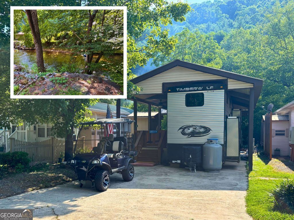 HIWASSEE RIVERFRONT OPPORTUNITY! Charming 2022 Timberwolf Limited Destination model with two slides, framed cover with porch, fenced dog run, and storage shed. With a modern design, this model features a full kitchen with an island and pantry, dining nook, living area with an electric fireplace, laundry closet, bedroom, full bath, and two double lofts for additional sleeping quarters. Outdoor living features a large covered porch with steps leading to your private river access. Located in the well-kept golf cart resort community with superb amenities, including a saltwater pool, pavilion with kitchen, shuffleboard, stocked fishing pond, and other community activities. Enjoy the ultimate outdoor lifestyle - trout fishing, kayaking, or floating in the pristine waters of the Hiwassee River from your own backyard.