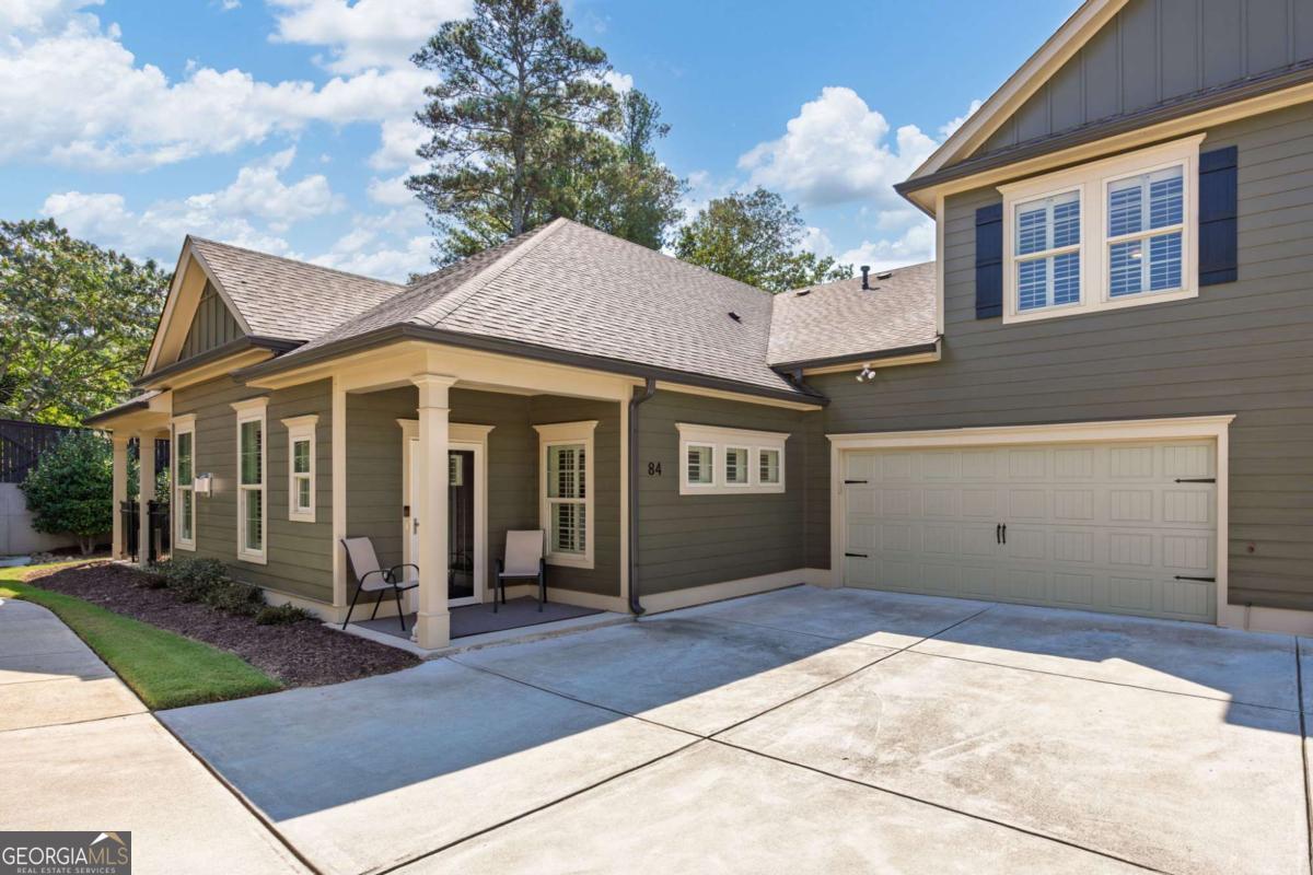 Elegant living in a sought-after lifestyle community! Welcome to 84 Cedarcrest Village Lane, a beautifully maintained 3-bedroom, 3-bathroom home tucked away at the back of a quiet, desirable neighborhood. From the charming covered front porch to the thoughtfully designed interiors, this residence blends comfort, style, and convenience. Inside, hardwood floors, high ceilings, and custom wood shutters create a warm and inviting atmosphere. The open-concept living area features a vaulted ceiling, a cozy fireplace, and a spacious dining area with coffered ceilings-perfect for everyday living or entertaining. The gourmet kitchen is a showstopper, offering white cabinetry, granite countertops, stainless steel appliances, a large center island with a breakfast bar, a walk-in pantry, and even a built-in desk for added functionality. The main-level primary suite impresses with a tray ceiling, custom closet, and a luxurious ensuite bath featuring a double vanity with granite countertops and a tile stepless shower with a bench. An additional bedroom with an attached full bath and a convenient laundry room are also on the main floor. Upstairs, a third bedroom can be used for guests or as a family room, office, or craft room. There is a walk-in closet and a full bathroom. Step outside to a fenced covered patio overlooking beautifully landscaped grounds-ideal for quiet mornings or evening gatherings. A two-car garage provides ample parking and storage. Residents of this vibrant community enjoy access to a clubhouse complete with a fitness center, kitchen, lounge, and library. With Bentwater Golf Club and Acworth Health Park nearby, plus shopping and dining just minutes away, this home is the perfect blend of location and lifestyle!