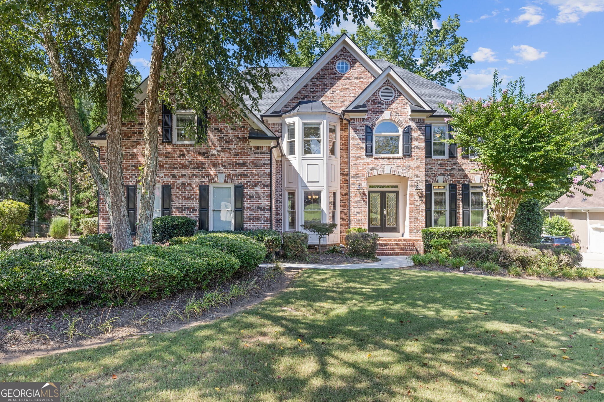 Incredible Opportunity in Polo Golf & Country Club! Don't miss this rare chance to get into the sought-after Polo Golf and Country Club in Cumming, GA at an exceptional value! This stately 5-bedroom, 4.5-bath brick home on a finished basement sits on one of the best lots in Polo a quiet cul-de-sac with nearly an acre of flat, usable yard that backs to protected wooded green space. It's the perfect blend of privacy, space, and prestige. Step inside to find a popular open-concept floor plan, featuring a bright and airy two-story family room with dramatic floor-to-ceiling windows that flood the space with natural light. The open kitchen flows seamlessly into the living area, ideal for everyday living and entertaining. The main level offers a guest suite, private study, and a formal dining room giving everyone their own space. A year-round sunroom and spacious deck overlook the tranquil backyard, creating the perfect setting for outdoor entertaining or quiet mornings with coffee. The finished basement provides additional flexible living space, while the 3-car side-entry garage offers plenty of room for vehicles, storage, and more. This is a home with incredible potential a solid, well-loved property just waiting for a new owner to come in, update, and make it their own. With its unbeatable lot, functional layout, and prime location within one of Forsyth County's most desirable neighborhoods, this one is a true gem. Home is part of an estate trust and is being sold as-is with no seller disclosures.