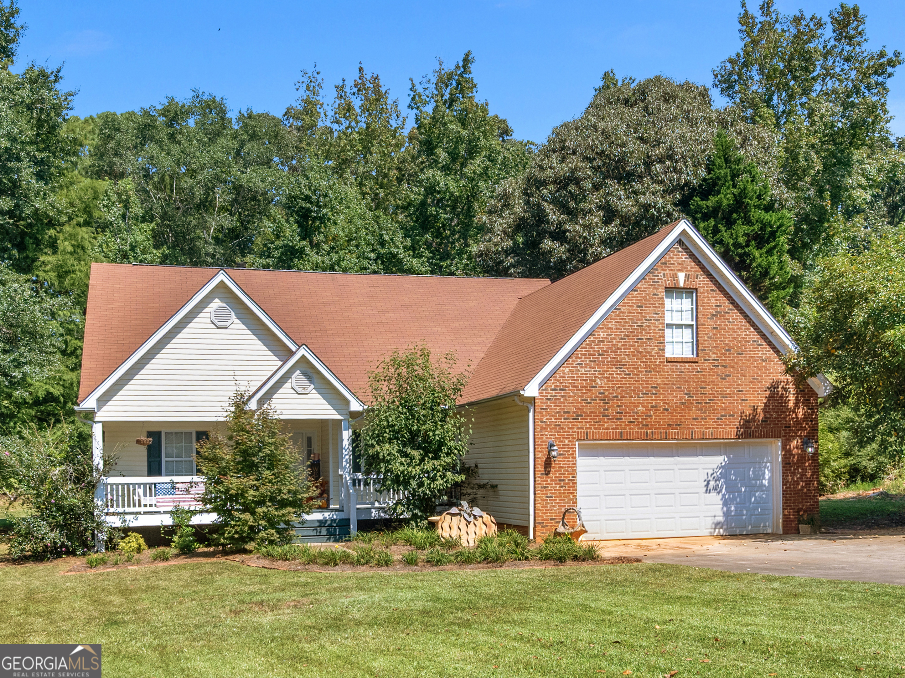 Welcome to this charming home located just minutes from Jackson Lake in a wonderful, established community. This 3-bedroom split plan offers all bedrooms on the main level with a versatile bonus/flex room upstairs, (not pictured)perfect for a home office or hobby space. Formal dining room with a beautiful tray ceiling, a two-story great room with a cozy fireplace, and an updated eat-in kitchen featuring striking black and glass cabinets, upgraded pull-out drawers, and elegant quartz countertops. The spacious primary suite includes a walk-in closet, garden tub, and separate shower, while two additional bedrooms on the main share a full bath. Enjoy relaxing on the covered back porch as you take in the peaceful natural setting or sip your morning coffee on the welcoming rocking chair front porch. This total electric home has hardwood floors in the main living areas, carpet in the bedrooms, and plantation shutters that remain with the home. Additional features include a two-car garage, a 12 x 20 storage shed, and a private fenced one-acre lot. The roof is less than 10 years old, the fireplace was cleaned within the past two years, and the water heater is approximately four years old. Move-in ready and ideal for a first-time buyer, this home offers the perfect blend of comfort, style, and convenience.