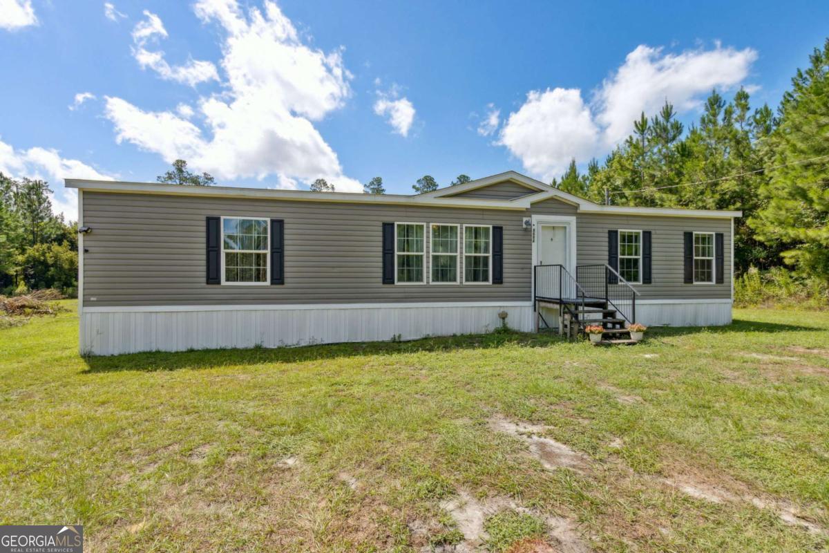 Escape to peaceful country living with this beautifully maintained 2019 mobile home nestled on 8 private, wooded acres in a highly desirable area of Folkston. This spacious home offers an open floor plan filled with natural light, creating a warm and inviting atmosphere from the moment you walk in. Inside, you'll find a split-bedroom layout for added privacy, a large kitchen island perfect for meal prep or casual gatherings, and an eat-in kitchen ideal for family dinners. Ample storage throughout ensures everything has its place, making daily living simple and organized. Step outside and enjoy the serene wooded lot, complete with your very own pond-a perfect setting for outdoor relaxation, exploring nature, or adding a few farm animals. With no restrictions on land use, you have the freedom to create your ideal lifestyle-whether that's a homestead, recreational property, or future investment.
