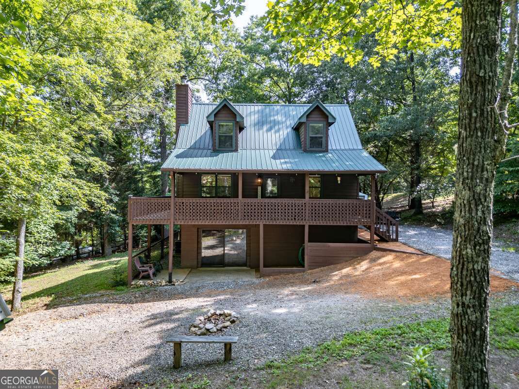 Welcome to a beautiful North Georgia mountain home that offers the perfect blend of comfort, privacy, and convenience. This 3-bedroom, 2-bathroom cabin sits on a gently sloping, usable .76-acre lot with mature trees and peaceful surroundings-ideal for anyone looking to enjoy the natural beauty of the region. Located just minutes from both downtown Blairsville and Murphy, NC, this home is in a prime spot for either a full-time residence, vacation getaway, or short-term rental investment. The main level features an open-concept layout with hardwood floors, a spacious living area centered around a wood-burning fireplace, and a modern design that complements the rustic charm of the mountains. The kitchen is equipped with granite countertops, a tile backsplash, and ample storage. Downstairs, the finished basement adds flexible space with a game room, bonus room, laundry area, and extra storage-perfect for entertaining guests or creating a private guest suite. Step outside and enjoy mountain living at its best on the wrap-around deck, screened porch, or by the firepit. The level yard is great for outdoor activities, while two storage sheds offer even more functionality. Secluded enough for peace and quiet, yet close enough to town for shopping, dining, and recreation, this property offers the best of both worlds. This is more than just a home-it's a place to enjoy, invest in, and make your own.