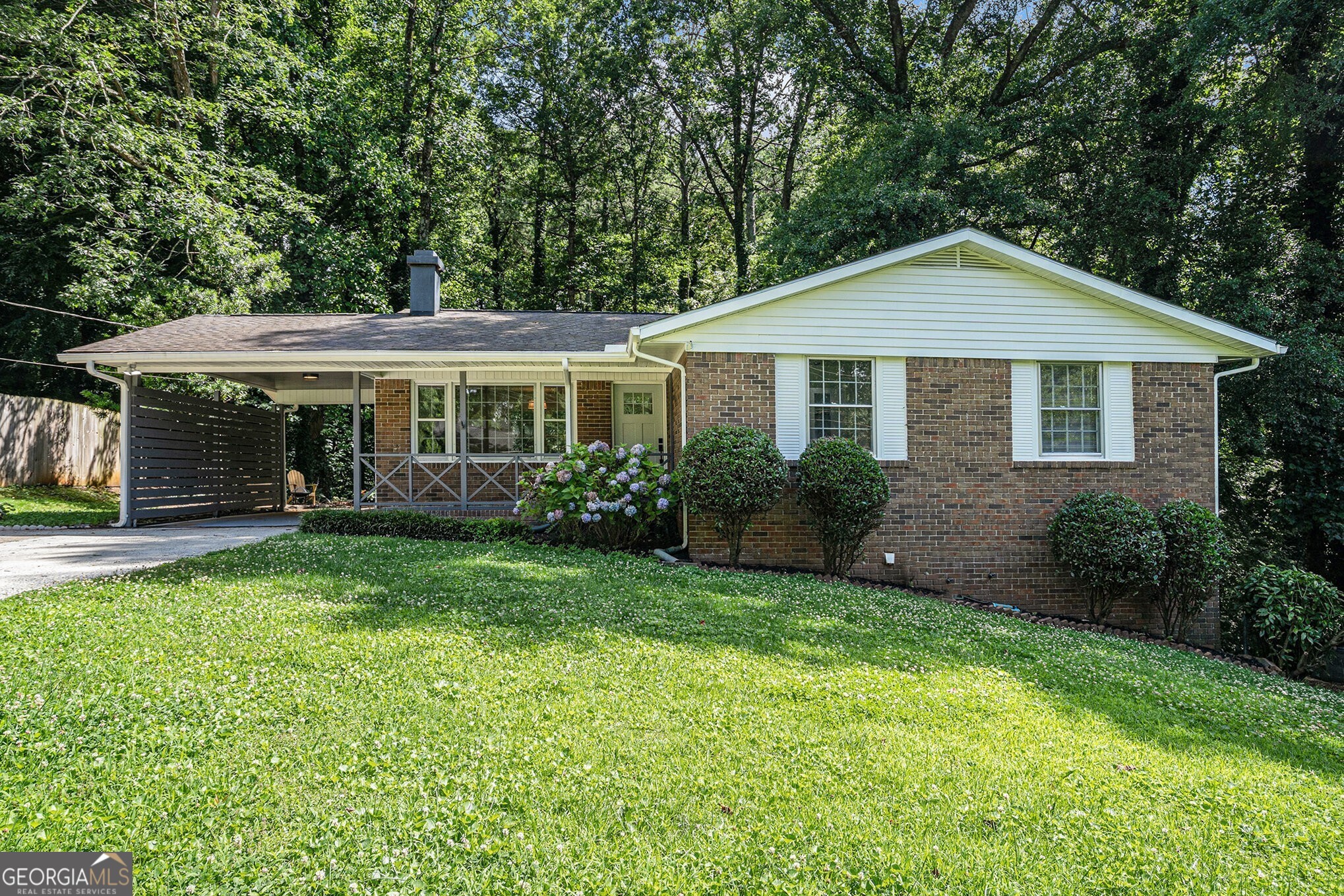 Up to $12,500 Toward Closing Costs or Rate Buy-Down! Step into this Fully Renovated Four-Bedroom, Two-Bathroom Ranch where classic charm meets modern style on a spacious Half-Acre Lot just minutes from the Silver Comet Trail, The Battery, and Smyrna Market Village. Inside, every detail shines with Fresh Paint, Refinished Hardwood Floors, and Designer Updates throughout. The bright, open layout begins in a welcoming Living Room with a Cozy Fireplace that flows seamlessly into a Sunlit Dining Room. A true centerpiece, the All-New Kitchen features Custom Cabinets, Quartz Countertops, Stainless Steel Appliances, and a Cheerful Breakfast Nook with access to the Rear Deck overlooking a tranquil, wooded Backyard. The Primary Suite offers an Updated Ensuite Bath, while two additional Bedrooms share a Beautifully Renovated Hall Bath. Downstairs, the Partially Finished Basement expands your options with a Fourth Bedroom/Home Office/Gym, a Workshop with Built-In Workbench, and plenty of space for storage or future growth. Pull into the Attached Carport and enjoy charming backyard views the moment you arrive. Outside, entertain or unwind on the Rear Deck or Lower Stone Patio, both nestled in a Private, Wooded Setting. This is a Turnkey Opportunity in a coveted location don't miss it!
