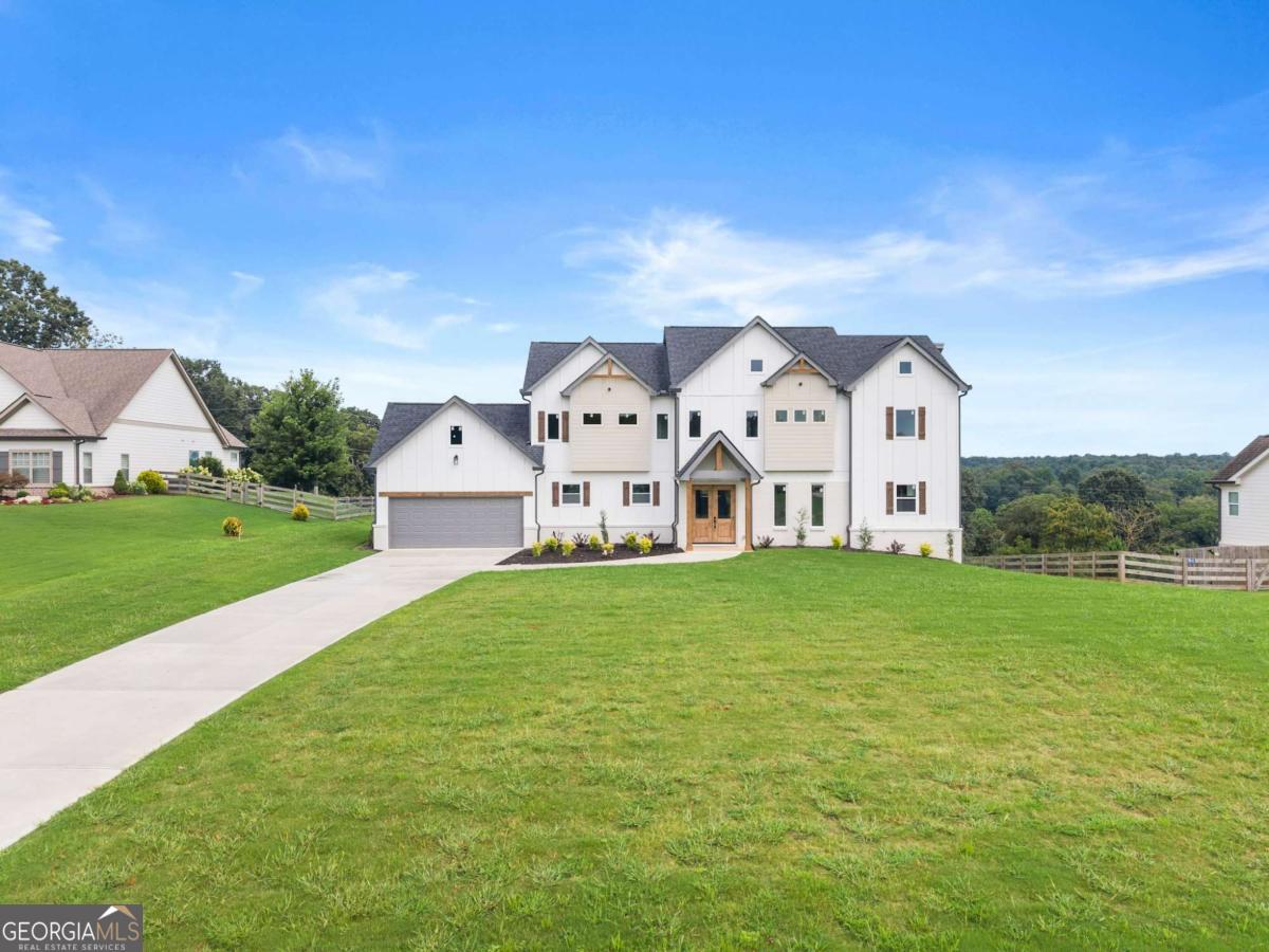 Experience luxury living at its finest in this one-of-a-kind new construction masterpiece-far from cookie cutter and crafted with unmatched attention to detail. Perfectly positioned on a premium 1.27-acre lot in the highly sought-after Avalon Commons swim/tennis community within the award-winning North Hall School District, this home captures breathtaking mountain views and offers a sprawling yard ideal for both play and entertaining. From the moment you step inside, you're greeted by rich hardwood floors, soaring 10' ceilings on the main level, and oversized windows that drench every space in natural light. The modern chef's kitchen is a true showstopper, featuring a massive quartz island, extra cabinetry for exceptional storage, and sweeping sunrise views to start each day beautifully. Just off the kitchen, a spacious separate room awaits-perfect as a keeping room or large breakfast area. The flexible floor plan includes a main-level space ideal for a formal dining room, elegant living room, or private home office, complemented by striking accent walls and gorgeous luxury trim work throughout. Step out onto the expansive deck to savor your mountain backdrop or host unforgettable gatherings. Offering 4 bedrooms, 4 full bathrooms, and 2,878 sq ft, this home showcases multiple fireplaces-including one in the lavish primary suite, where the spa-inspired bathroom invites pure indulgence. The custom closet systems are what domestic dreams are made of, bringing both beauty and functionality to your daily routine. Priced below appraised value, this property delivers the kind of finishes, lot size, and views you simply won't find at this price anywhere else.