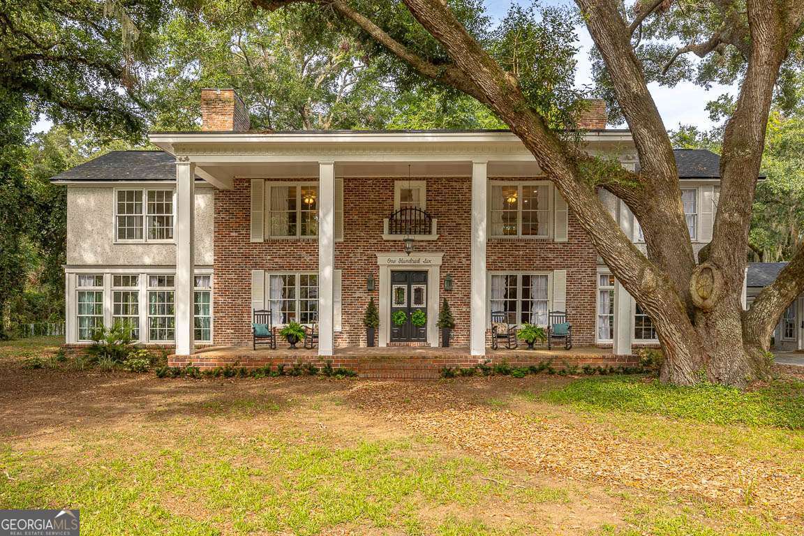 Step back in time and savor the beauty of this charming 1932 estate-a true Southern gem. Nestled on 1.95 acres of oak-shaded tranquility, it's a perfect blend of historic grace and modern comfort, offering peaceful seclusion while keeping all the sought after destinations of St. Simons Island within easy reach. The main house welcomes you with 4 bedrooms and 4 full baths, lovingly restored to honor its 1930s heritage with all the conveniences of today. Step onto the original heart pine floors, admire the stately fireplace mantels, slide open the pocket doors, and linger by the built-in library bookcases with their cozy window seat-it's pure Southern elegance in every corner. In the heart of the home, a grand chef's kitchen awaits: vaulted 13-foot ceilings, a generous 9-foot island, reclaimed brick backsplash, vintage windows from old Glynn Academy, and a farmhouse sink that whispers of simpler times. A hidden pantry keeps things organized, while premium appliances like the ZLINE 48 and Paramount Double-Oven Dual-Fuel Range make cooking a delight. Entertaining is effortless here: a spacious 1224 covered porch set on a solid slab beckons for lively gatherings and quiet mornings with coffee. Sunlight pours through wall-to-wall windows in the living and sunroom areas, and a newly added wet bar with custom cabinetry keeps every soiree flowing smoothly. The primary suite is your private haven, a generous walk-in closet/dressing room adorned with classic millwork and warm finishes that make every day feel indulgent. Beyond the main residence, discover a fully renovated 400 sqft. apartment complete with its own kitchen and bath, perfect for welcoming guests, in-laws, or serving as a charming rental. Meticulously updated throughout with new HVAC, electrical, plumbing, tankless water heater, roof, insulation, drywall, and fresh paint, this home blends historic character with carefree, move-in-ready ease. It isn't just a house it's a slice of Southern history, re-imagined for today's lifestyle. Whether you're searching for a private retreat or a gracious venue for entertaining, this estate is poised to welcome you home.