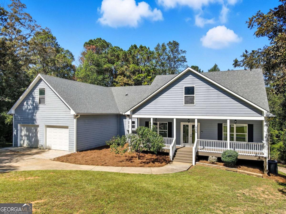 Welcome to Ball Ground, Georgia! This custom-built 5 bedroom, 3.5 bathroom ranch on a finished daylight basement sits on 5.95 acres and offers the perfect balance of space, privacy, and convenience. Built in 2015, the home features a split-bedroom design with the master suite, laundry, and half bath on one wing, and two spacious bedrooms with a full bath on the other. The open kitchen overlooks the vaulted great room, making it the heart of the home for gatherings and entertaining. There is also potential to finish a room above the garage for even more living space! The finished basement adds incredible versatility with two additional bedrooms, a full bath, a large living room, and a home office-perfect for multigenerational living, guests, or a private workspace. Outdoor living shines with a rocking chair covered front porch, a large back deck that's half covered and half uncovered, plus a screened patio area underneath. The fenced backyard is ideal for pets, play, or future expansions. The property itself combines open usable yard space with hardwoods in the back, giving you room to garden, ride, hike, or hunt right at home. A true standout feature is the 35'x55' (1,925 sq. ft.) three-bay shop, built in 2018 with 12'x12' roll-up doors, water, and power-ideal for a workshop, home business, or storage for RVs, boats, and toys. All of this with no HOA, county-only taxes, and walking distance to downtown Ball Ground, yet only minutes from shopping, dining, wineries, and I-575 for easy commuting. Peaceful country living with room to spread out-right where you want to be!