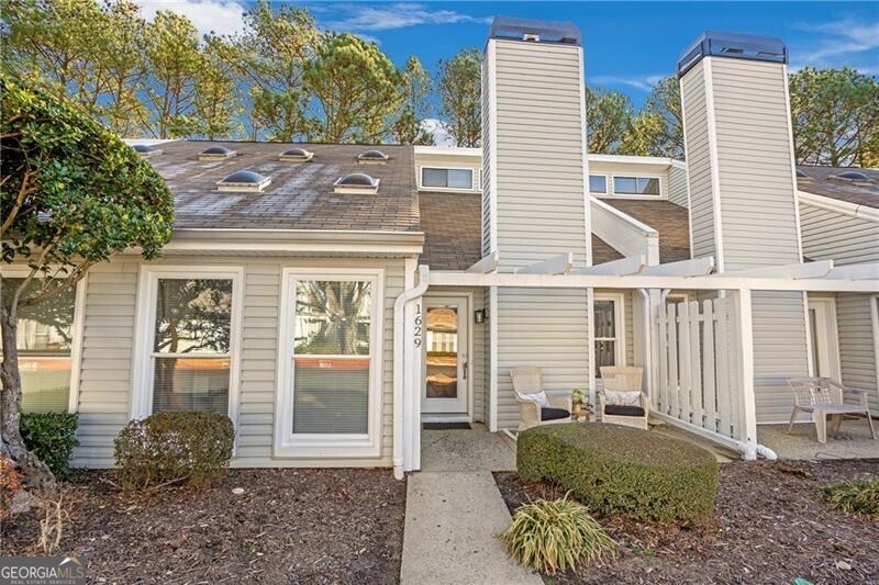 Live, Work, and Play just 1 mile from the heart of downtown Alpharetta! This light filled primary on main condo has been fully renovated in 2023. From the moment you step inside this home, you are greeted by a bright, airy two-story great room with LVP flooring and gas fireplace with black marble header and custom wood mantel. The open concept dining area flanks the kitchen with shaker style cabinets, stainless steel appliances, subway backsplash, quartz countertops and recessed lighting. The adjacent sunroom is a perfect place to make a sitting room, home office, art studio, or reading nook. The primary ensuite, located on main floor, has a spacious walk-in closet and access to a rear patio with privacy fence. Ensuite bathroom features, shaker style cabinets, quartz countertop, his/her vanity, walk-in shower with niche, tile floors and floating wood shelves for convenient linen storage. The upper level includes two secondary rooms that can be used as additional bedrooms, extra office space, or play/bonus/media rooms, a guest bathroom with similar considerations as the primary ensuite plus a separate laundry closet with cabinets for extra storage. New HVAC (2024), full window replacement excluding skylights (2023), newer water heater (2023). Two assigned parking spots right outside front door. Utility storage closet located on rear patio. Community has pool and tennis with sidewalk access to downtown Alpharetta to enjoy A++ restaurants, unique shopping boutiques, live entertainment, cafes, green space, and community events. No rental restriction cap, but rentals must be 6 mos or longer. Amazing opportunity for an investor or someone looking for a modern low maintenance lifestyle. 1.1 miles to GA-400, and 2 minutes to Avalon or Windward Pkwy- This location is unbeatable!