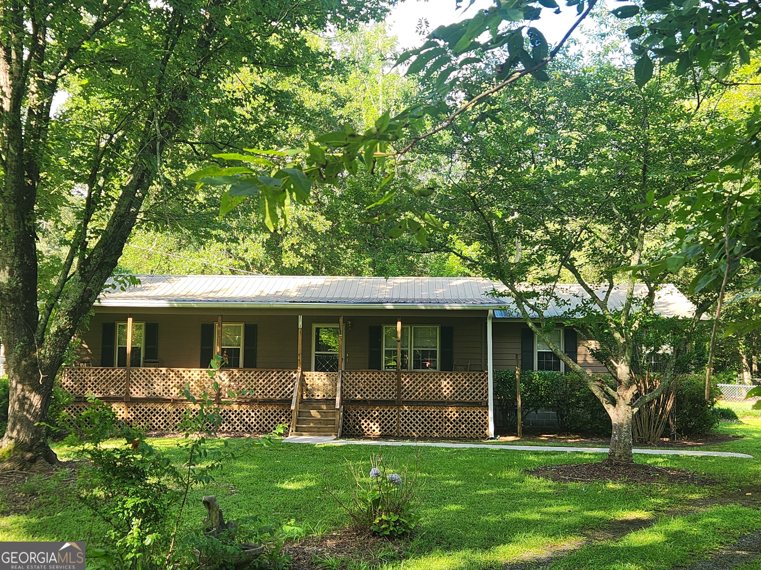 3/2 Ranch on 3.94 acres. This split floor plan is looking for a family to come make it their own. Nice front rocking chair porch, fenced in back yard, & a barn for whatever your hobby may be. The detached double garage has a lean to with a RV camper amp box. The yard has figs, muscadines and plenty of beautiful trees for privacy. Set up your showing today! This property is priced to sell.