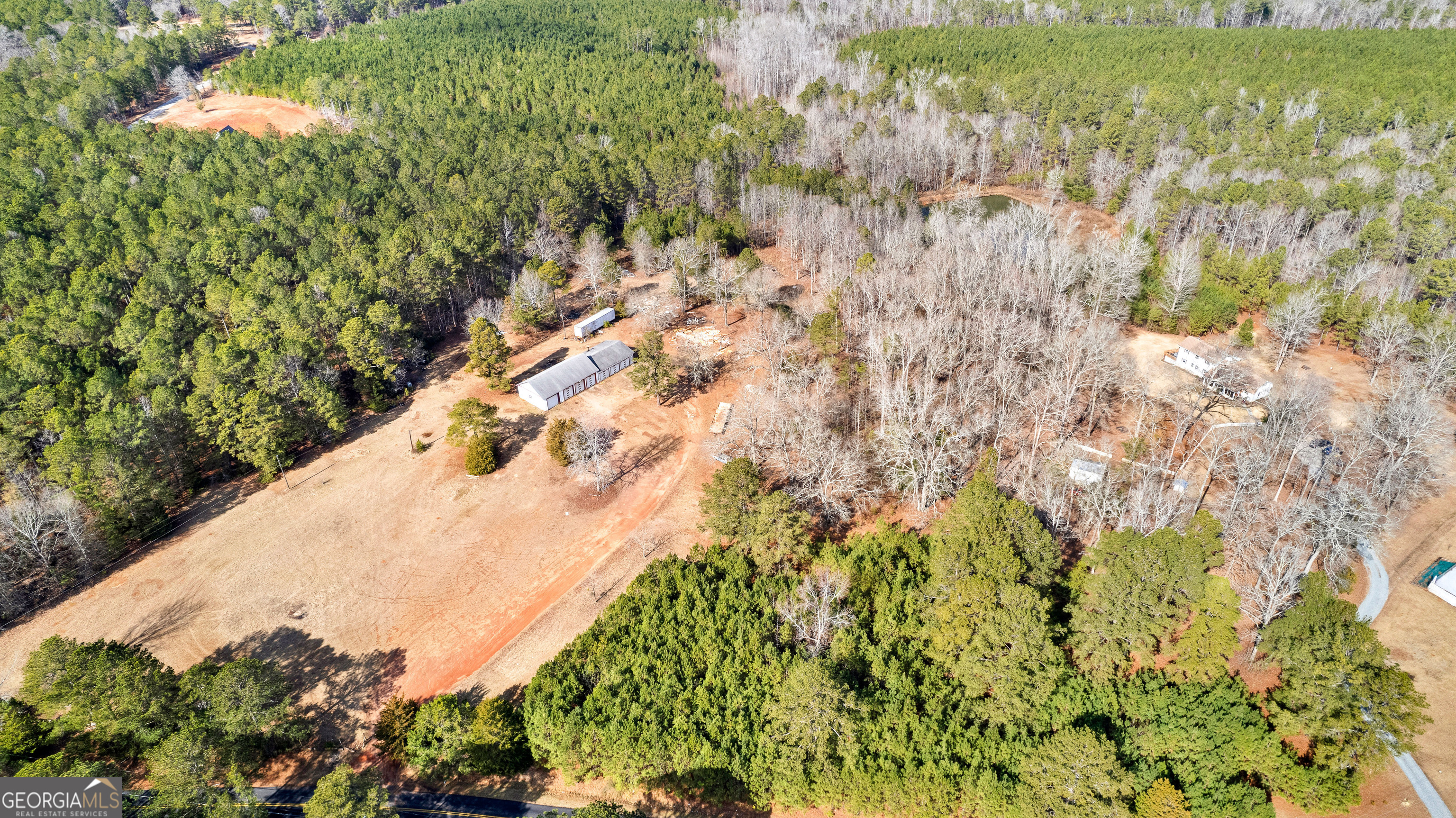 Discover the perfect blend of privacy and potential on this stunning 20-acre property. Ideal for building your dream home, it features a 7-bay shop, providing ample space for storage or projects. With electricity, water, and propane already in place, development is made easy. The land offers a mix of wooded seclusion and partially cleared, level areas, ideal for future builds or recreational use. A peaceful pond adds to the property's natural charm, creating a serene backdrop. Zoned AR and encompassing both Parcel 046 065 and Parcel 046 065A, this versatile property offers countless opportunities. Whether you're seeking a private retreat or a place to bring your vision to life, this property delivers endless possibilities. Schedule a visit today to explore all it has to offer.