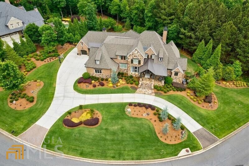 Exquisite transitional estate home that is truly magazine worthy! Gorgeous finishes and fabulous floor plan combine to deliver one of the most amazing home to hit the market in prestigious The River Club. The welcoming front porch has plenty of room for you to sit and linger longer. The foyer with shiplap walls sets the stage for elegance throughout the house. Beautiful dining room has stunning chandelier and custom ceiling. Great room opens seamlessly to huge outdoor entertaining deck with fireplace, bar and outdoor kitchen. The main kitchen with double islands is outstanding and will quickly become your favorite place in the house! It opens to inviting keeping room with beamed ceiling. Luxurious master suite has all the features you crave including super-sized shower. Do you want the nicest laundry room in the community? Check! The first floor is completed with large mud room and an office with its own deck. Upstairs are four oversized secondary bedrooms with ensuite bathrooms and walk-in closets. The terrace is awesome with HUGE exercise room, batting cage (really!), steam room, media room, billiards room and more! The grounds are fabulous with sparkling pool-n-spa, 4 garages, extra large driveway for plenty of parking, and tons of yard to run.