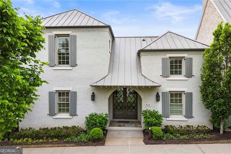 URBAN OASIS AT AVALON Turnkey condition and designer finishes, paired with a sought-after Avalon location close to top-tier schools and public transportation, position 346 S Esplanade as a truly exceptional property. Located minutes from Westside Parkway and Old Milton Parkway within Fulton County's coveted Hopewell Middle and Alpharetta High School districts, this contemporary-style gem offers 5,662+/- square feet of elegance on two levels. Commencing with an inviting entrance foyer leading to a guest suite complete with a full bathroom and a separate office, the main level integrates hardwood floors and high ceilings with insulated windows that bathe the interior in abundant natural light. A wall of accordion doors effortlessly extends the unrestricted living/dining/kitchen space outdoors to a courtyard complete with a fountain and well-kept green space. Revel in fireside comfort while entertaining in style. Equipped with professional-grade stainless steel appliances, the chef's kitchen boasts stone countertops, a walk-in pantry and an oversized island, complemented by a mudroom with a drop zone and direct access to the three-car garage. A covered patio with a fireplace and an outdoor grill area invites al fresco dining and relaxation regardless of the season. Upstairs, discover four additional bedrooms and four full bathrooms and an open loft space with built-ins that could easily become a playroom or a home gym. Light-filled and retreat-worthy, the owner's en suite was designed for ultimate function, with dual bathrooms (each complete with a designated walk-in shower and vanity) leading to a spacious walk-in closet. A separate entrance to the fourth bedroom presents potential for an in-law suite, and the laundry room offers ample storage and workspace. The Avalon community offers residents the pinnacle of luxury low-maintenance living. Boasting premier North Atlanta shopping, dining and spa facilities, it also offers amenities such as access to the inground community pool, the Greenway/trails and public transportation. Embrace the warmth and excitement of the modern South with easy access to every convenience at 346 S Esplanade, where every detail has been meticulously curated for the discerning homeowner. Welcome home.