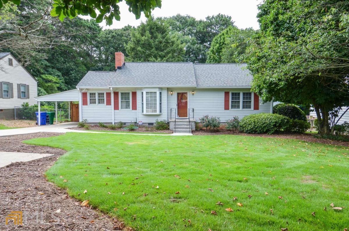 ** RANCH home on HUGE deep lot ** The elongated flat driveway plus additional turn-around parking pad provides ample space. The front entry welcomes you into the family room featuring brick fireplace with wood mantle which opens up to the dining room/eat in kitchen area. The galley style kitchen offers tons of cabinet storage & countertop space, stainless steel fridge, dishwasher & microwave. The front guest room includes a custom built in bookcase that has a hidden murphy bed! The back bedroom boasts plenty of space and overlooks the large backyard. The hall bath features tub/shower combo & extended vanity. The laundry/utility room off the kitchen offers great storage/flex space and includes a raised tub, perfect for a dog bath! The backyard features a wooden deck with custom dog run/kennel area on the side. You will fall in LOVE with the large flat, deep, & private lot with luscious green grass & established tree line. PRIME location close to shopping, restaurants, local parks & quick access to I85, I285, & Highway 78! PROPERTY SOLD AS IS!