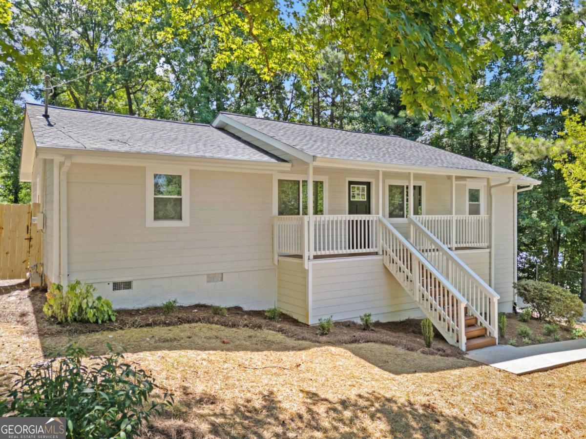Welcome home to this Completely Renovated hard to find 4BR/2BA Ranch on almost a half acre of flat private fenced back yard in the growing area of Mableton. New new new!!! New "rocking chair" front porch welcomes you into expansive open floorplan. Home features new windows throughout with lots of natural light. New flooring, inside/outside paint with SMOOTH CEILINGS and lots of updates!. Kitchen features a new slow-close white shaker cabinets, new backsplash tile, Quartz countertops, Large Island with additional eat-in area and all new stainless-steel appliances, Large Master bedroom with Master Bathroom features his/her vanities and new Tiled shower, Home features nice size secondary bedrooms, all new interior doors, and new higher-end LVP throughout, New HVAC rounds out this home as move-in ready! Exterior includes all new Siding, new expanded Driveway with turnaround, new back deck, and new Roof! Crawlspace is huge allowing for room for a workshop and storage! No HOA!!! This almost new home offers convenient access to highways, schools, and shopping. Tax records do not reflect 2nd bathroom.