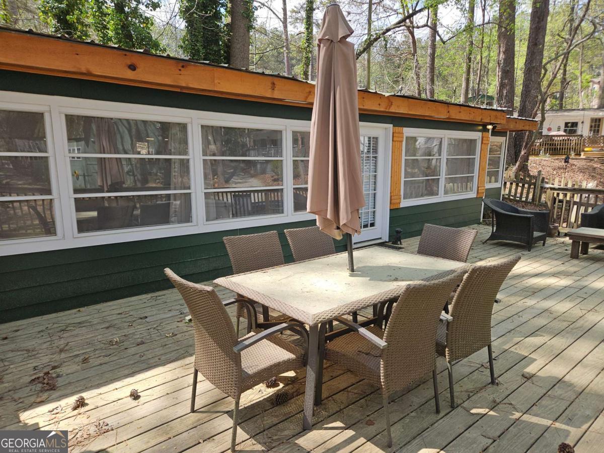 Summertime is Lake time! Charming bungalow in Atlanta Boat Club, a gated community of vacation cottages on Lake Allatoona! This property boasts it's own swimming dock on the Lake, three bedrooms, one and a half full baths, an updated kitchen with granite and newer appliances, dining area, living room that opens to a covered patio, washer and dryer, LVP flooring and an expansive deck with view of the Lake. Atlanta Boat Club leases the property from the Army Corps of Engineers; you are only purchasing the structure and the accompanying swimming dock. The cottage can not be lived in full time nor rented out, per Corps rules. Atlanta Boat Club offers a clubhouse for holiday parties and get-togethers, covered boat storage, a gated entrance, common areas/roads/grounds maintenance.