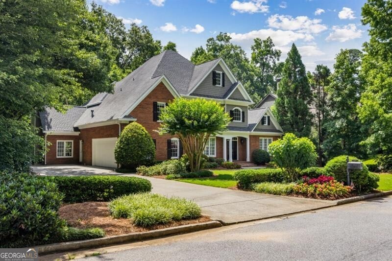 Nestled at the end of a quiet, tree-lined cul-de-sac in one of Sandy Springs' most sought-after neighborhoods, this stately brick residence masterfully blends timeless architecture with modern sophistication. From the meticulously manicured lawn to the grand front entry, every detail sets the tone for an elevated lifestyle. Step inside to a soaring foyer with newly refinished hardwoods and a dramatic staircase accented by custom iron balusters. The formal dining room offers presence and polish with deep crown molding, classic wainscoting, and plantation shutters-equally suited for candlelit dinners or large-scale entertaining. The fireside living room delivers warmth and versatility, perfect as a receiving space, office, or a quiet retreat. Anchored by a custom fireplace and built-ins, the main family room exudes quiet luxury, with a soaring arched window that captures peaceful views and natural light. At the center of the home, the chef's kitchen stuns with white cabinetry, quartz countertops, a statement two-tone island, and pro-grade stainless appliances. An adjoining breakfast room and keeping room-complete with vaulted ceilings, a floor-to-ceiling stone fireplace, and walls of windows-create a sunlit sanctuary that's equally inviting for everyday living and entertaining. Step outside to a spacious deck nestled in the treetops-perfect for dining al fresco, sipping your morning coffee, or enjoying the sounds of nature. A built-in workstation just off the kitchen adds discreet function for remote work or household organization. The main-level primary suite is a true sanctuary, featuring deep tray ceilings, elegant trim, lush views, and private deck access. Unwind in this serene, oversized retreat designed for rest, renewal, and privacy. Upstairs, four generously sized bedrooms offer hardwood floors, large closets, and abundant natural light, while three well-appointed baths feature crisp finishes and enduring style. The finished terrace level provides even more flexibility, with a large recreation room, full bath, and private bedroom-ideal for a guest or in-law suite. A screened-in patio below offers a shaded escape overlooking the private, wooded lot-perfect for play, pets, or a future firepit. Ideally located just minutes from Chastain Park, City Springs, top public and private schools, GA-400, and I-285, this exceptional home delivers both luxury and convenience. Whether you're dining in Buckhead, enjoying a show at the Performing Arts Center, or heading into the city, everything is at your Fingertips.