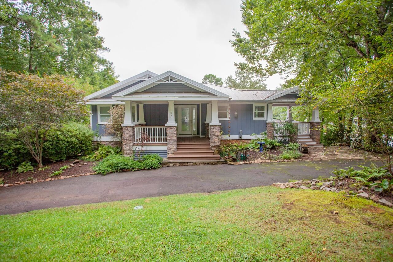 Bring your boat and enjoy LAKE LIFE! This charming craftsman cutie has the master suite on the main level and two additional bedrooms on the terrace level. Gorgeous Brazilian Cherry floors throughout. The sun room that over looks the lake could also be a great home office. The rock fireplaces add charm and warmth on a chilly night. Enjoy outdoor dining on the covered porch. Dock is made with composite decking in the quiet cove. Lots of built in cabinets. There is a great storage garage/ workshop for lake toys, cushions, kayaks, etc. Walking distance to the country club, golf course, tennis, and swimming pool. Enjoy 24 hour security behind the gates. 3 lakes, 3 lighted tennis courts, walking trails, pickle ball courts, 2 restaurants, marina, 2 pools, recreation center, and country club. Come see our amenities.