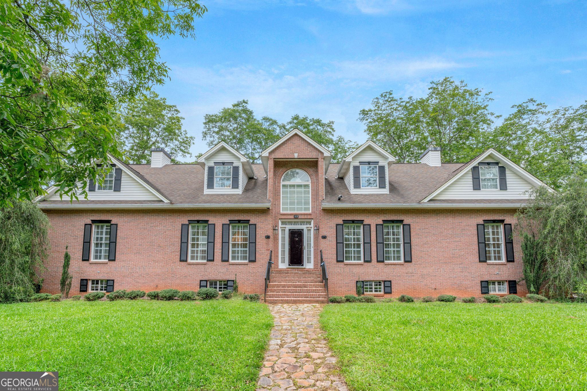 Stunning Custom-Built 4-Sided Brick Home on 5 Acres with Pecan Orchard This beautifully maintained, custom-built brick home offers an impressive over 4500 square feet of living space and over 2900 square feet of basement. Situated on 5 picturesque acres featuring a mature pecan orchard, this property blends classic charm with modern functionality and comfort. Inside, the home boasts 4 spacious bedrooms, 4 full bathrooms, and an abundance of flexible living spaces, including 2 large bonus rooms and a dedicated storage room. The main-level primary suite is a luxurious retreat featuring crown molding, a trey ceiling, a private dressing room, a gas-log fireplace above the soaking tub, a separate shower. The expansive kitchen spans the length of the home and is equipped with two pantries, a charming eat-in area with a bay window and built-in bench, and an adjacent laundry room for convenience. Generously sized separate dining and living rooms make this home ideal for entertaining. and direct access to a covered porch through elegant French doors. The lower level includes a 2-car garage, 2 finished rooms that could serve as additional bedrooms, a second laundry area, and ample space for hobbies or a home office. Upstairs, you'll find 2 additional bedrooms and a full bath, perfect for accommodating family or guests and a cedar lined closet. Additionally, the home features central vacuum, 2 hot water heaters, well water in addition to public water (valve to switch water supply), entertainment center wired for sound with ceiling flush mounted speakers, and plantation shutters. Minutes to downtown Barnesville shops and restaurants. With its versatile layout, elegant details, and peaceful setting, this exceptional home offers room to grow, entertain, and enjoy the beauty of country living-all just a short drive from local amenities. This home was built with care. Built with additional insulation in interior walls and extra support for stairs to prevent noise, a loft over the front door for a Holiday display and many more details you can see for yourself, there are many details in this home that make it special.