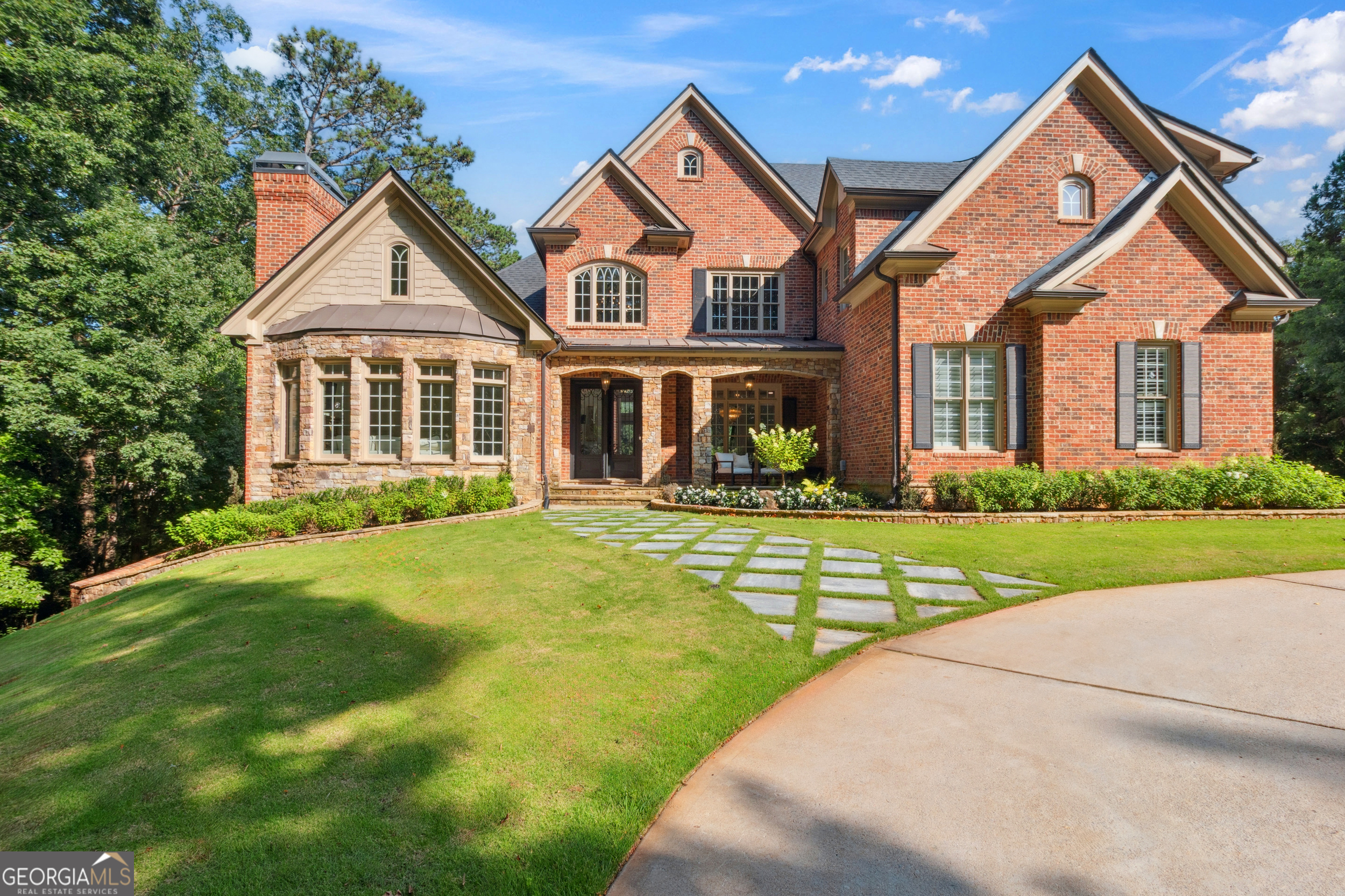 Privately tucked behind a long, tree-lined driveway and greeted by a graceful circular drive, this One-of-a-Kind Estate offers rare privacy and elegance on 1.8 acres in one of North Georgia's Most Prestigious Golf Communities. With direct Golf Course access and a sprawling backyard ideal for sports, entertaining, and relaxing, this property offers the ultimate blend of luxury and seclusion. Step through the Grand Two-Story Foyer, where extravagant designer lighting and custom trim set the tone for the rest of the home. The Main Level features a Formal Living Room with soaring ceilings, a dramatic black crystal chandelier, built-in bookcases, and a striking Two-Story Fireplace framed by Floor-to-Ceiling windows with custom molding. The Entertainer's Kitchen is a showpiece, featuring a massive island, professional-grade appliances, and seamless flow into the vaulted Keeping Room and informal living spaces. The Main-Floor Primary Suite is a true retreat, offering a private sitting room with fireplace, tray ceilings, and a luxurious ensuite bath with dual vanities, spa-like shower, and soaking tub. The oversized walk-in closet includes convenient built-in laundry access, creating the ultimate in functionality and flow. Just off the foyer, you'll find an expansive, vaulted study or home office wrapped in custom moldings with five large windows overlooking the serene lawn-perfect for working from home or a quiet reading space. Additional Main-Level highlights include a full Powder Room, and a Mudroom/Laundry Room combined space. Upstairs, you'll find three generously sized bedrooms-each with a Private En-Suite Bathroom as well as a fourth bedroom or bonus room with a closet, ideal for use as a bedroom, media room, or flex space. The Fully Finished Terrace level redefines Basement Living, boasting real hardwood floors, a richly paneled and custom-trimmed media room, expansive entertaining areas including a full bar, game room, fitness studio, and lounge. Just off the bar area is a warm and inviting living room with the homes sixth fireplace-perfect for casual gatherings. A sixth bedroom functions as a Second Master or In-Law Suite, complete with a Spa-like bath, Steam Shower, closet, fireplace, tray ceilings, sitting area, and private walk-out access to the pool. Outdoors, the Resort-Style Pool is framed by lush landscaping and surrounded by expansive green space-perfect for hosting guests or enjoying a private soccer or baseball game. The backyard connects directly to the golf course while remaining completely secluded from street view. Additional Features: * 6 fireplaces * 3 laundry rooms * Direct Laundry access in Master Closet * 1.8-Acre Golf-Course Lot * Resort-Style Pool with multiple lounging areas * Hardwood floors throughout, including Basement * Designer lighting, wallpaper & ceiling treatments * Extensive custom millwork and molding * Gated, Golf cart-friendly community This home is a rare opportunity to own a truly custom, move-in-ready masterpiece where elegance, functionality, and privacy come together in perfect harmony in the opulent resort community of Chateau Elan.